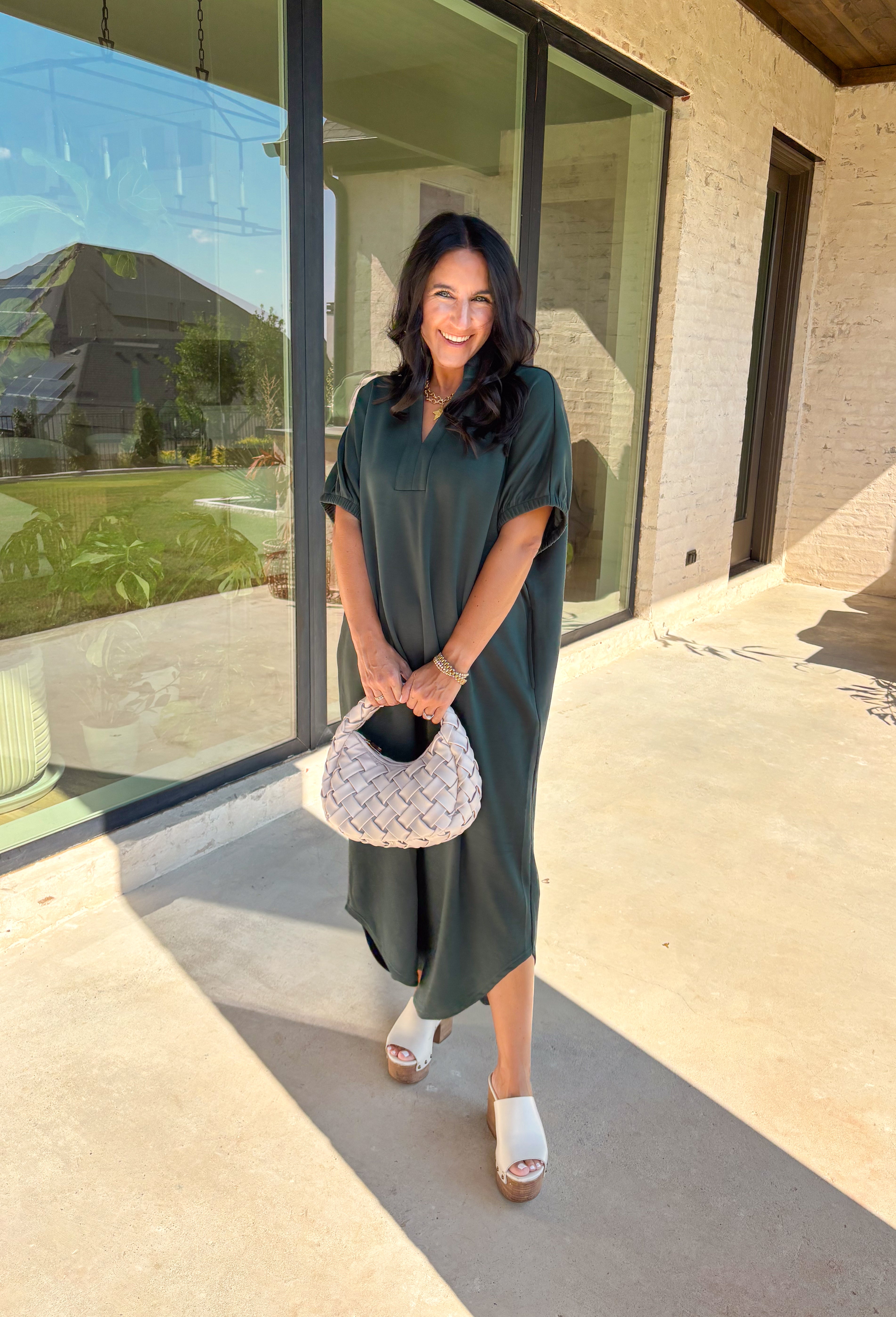 Effortless and versatile, this forest green midi dress is an easy favorite for fall. Designed with a band collar v-neckline and elasticated short sleeves, it offers both structure and comfort. Side pockets keep it practical, while the soft, stretchy fabric blend makes it perfect for all-day wear. You'll find yourself reaching for this dress all season long!