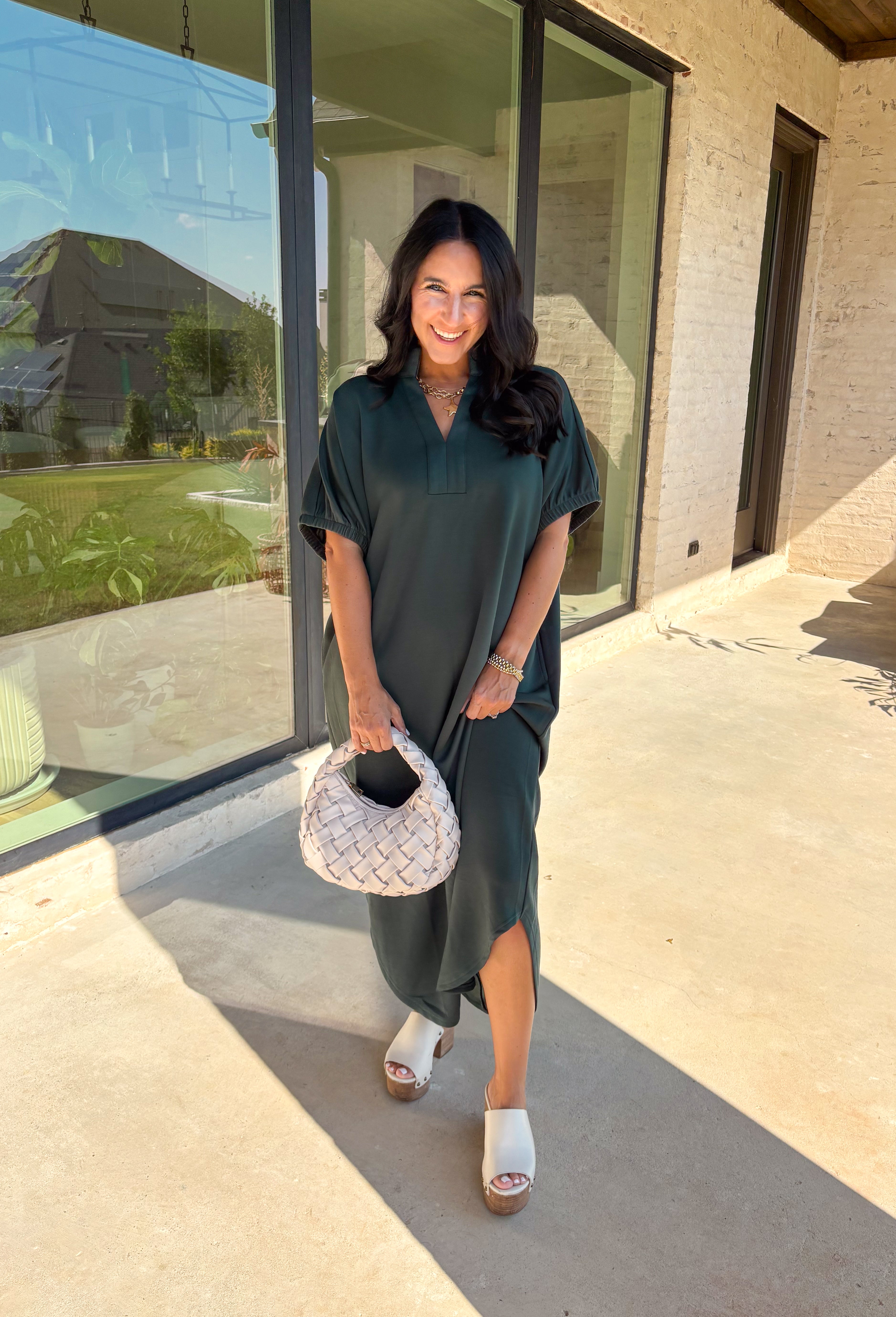 Effortless and versatile, this forest green midi dress is an easy favorite for fall. Designed with a band collar v-neckline and elasticated short sleeves, it offers both structure and comfort. Side pockets keep it practical, while the soft, stretchy fabric blend makes it perfect for all-day wear. You'll find yourself reaching for this dress all season long!