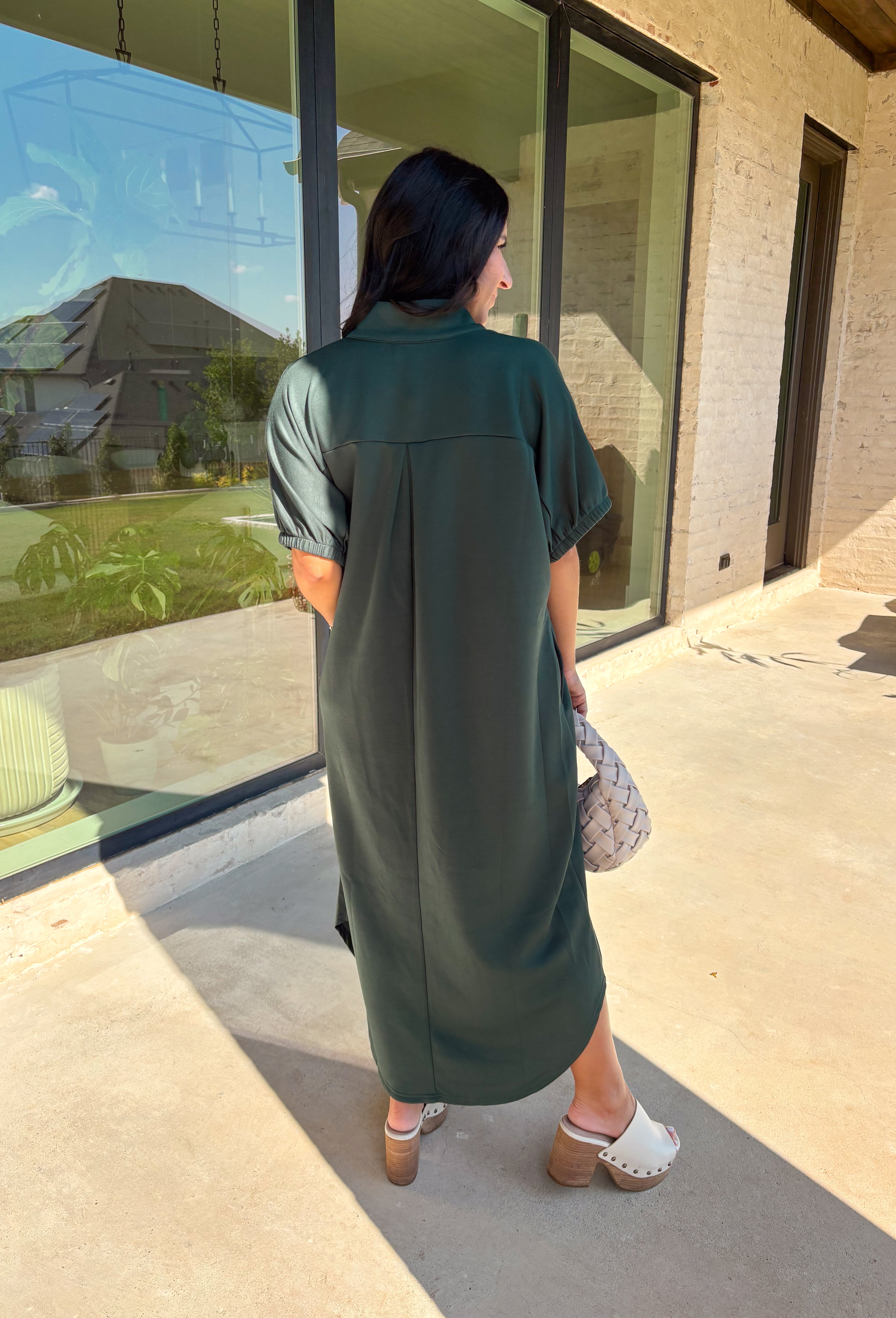 Effortless and versatile, this forest green midi dress is an easy favorite for fall. Designed with a band collar v-neckline and elasticated short sleeves, it offers both structure and comfort. Side pockets keep it practical, while the soft, stretchy fabric blend makes it perfect for all-day wear. You'll find yourself reaching for this dress all season long!