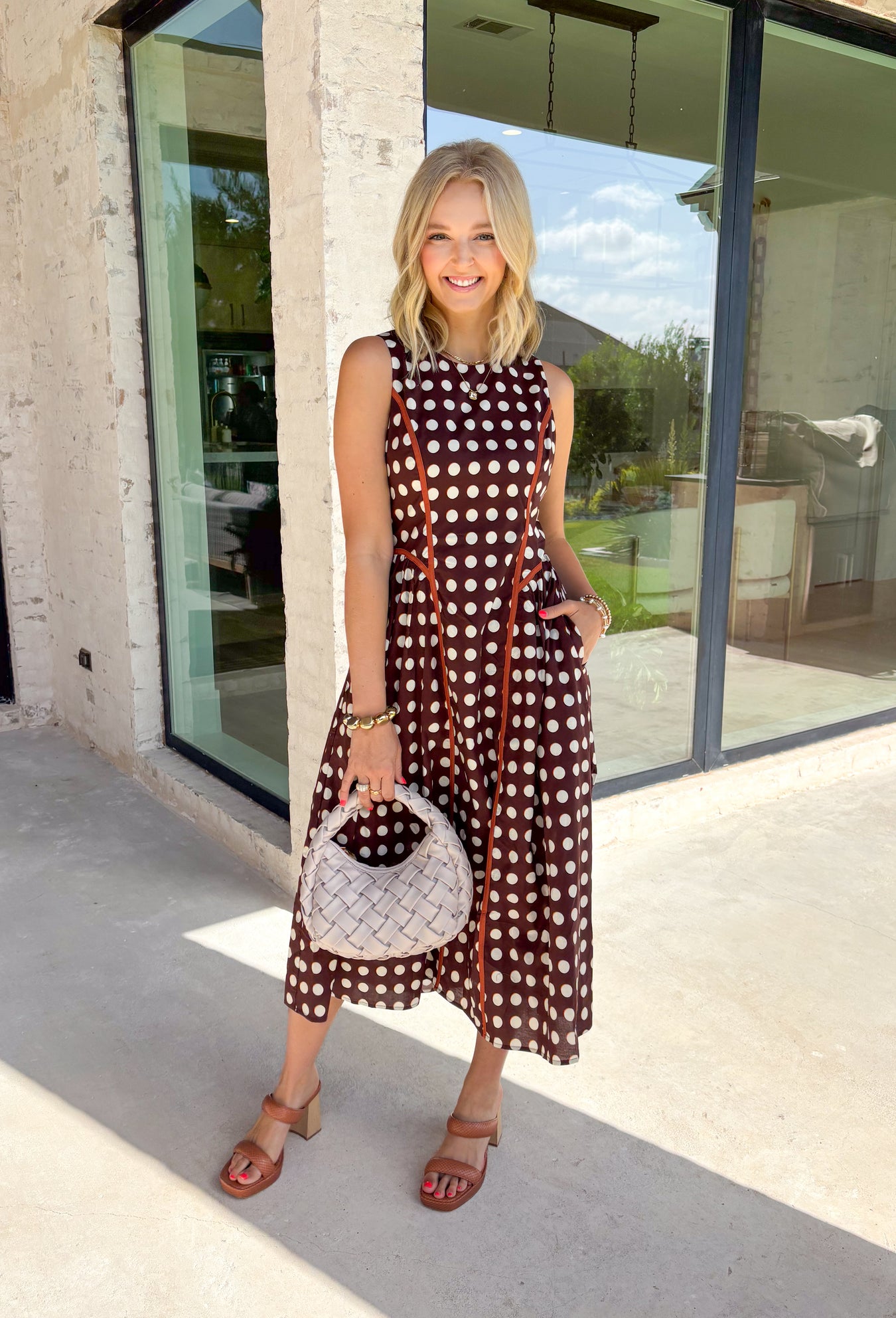 Classic polka dots never go out of style, and this charming midi dress from Entro is a timeless piece you'll wear for seasons to come. Designed with a rich brown backdrop and an off-white polka dot print, this sleeveless silhouette is effortlessly polished and easy to wear. Contrast piping adds a refined touch, while the back zipper creates a tailored fit. Finished with side pockets and a fully lined design, this cotton midi dress is perfect for everything.