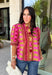 Bring playful pattern and timeless charm to your fall wardrobe with this beautifully detailed top from Entro. Featuring a unique mix of stripe and polka dot prints in rich shades of plum, magenta, and olive, this eye-catching blouse is perfect for adding personality to your everyday style. The feminine ruffle neckline and button-front design create a polished look, while the short puff sleeves are finished with smocked ruffle cuffs for an extra touch of charm. 