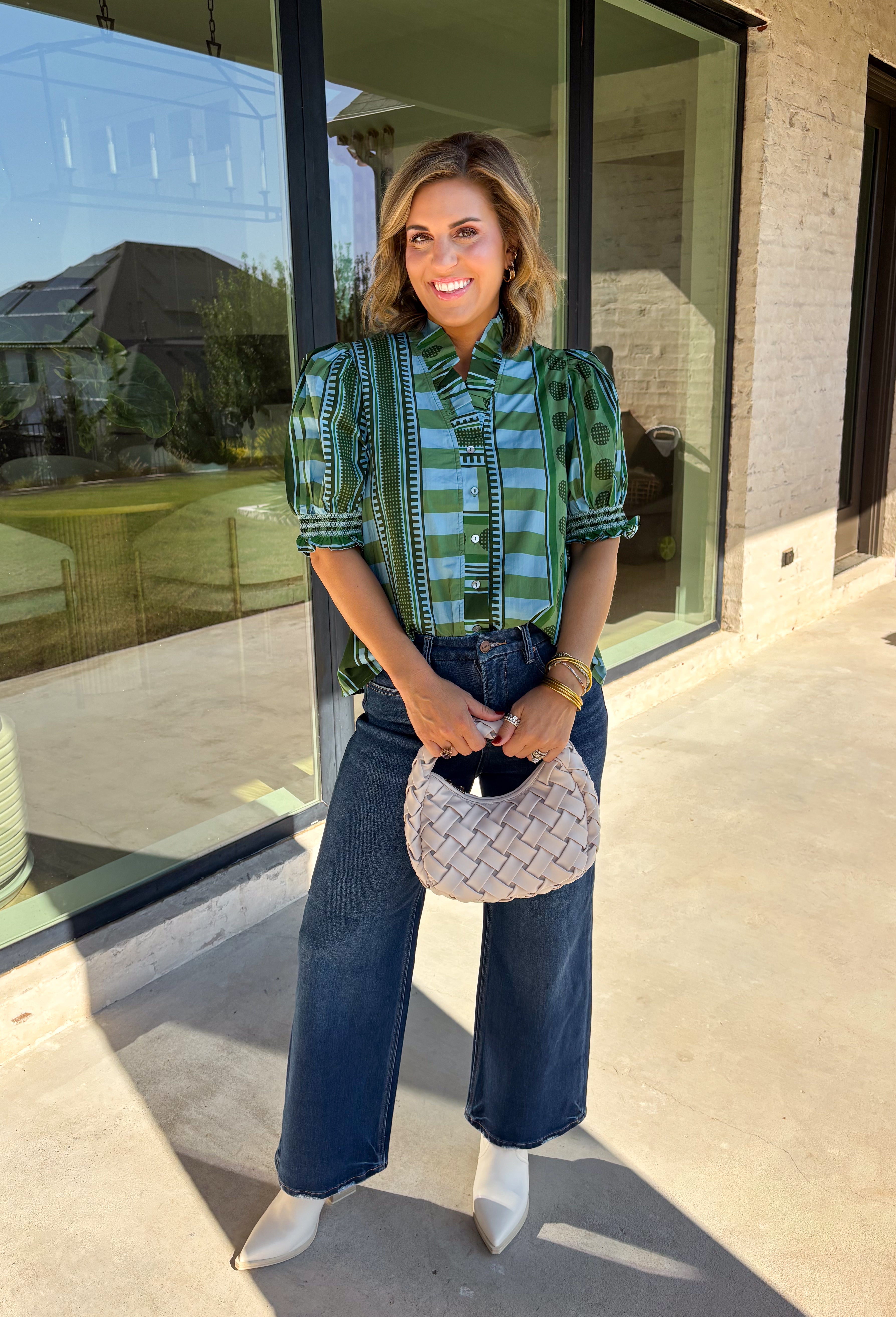 Bring playful pattern and timeless charm to your fall wardrobe with this beautifully detailed top from Entro. Featuring a unique mix of stripe and polka dot prints in rich shades of olive and blue, this eye-catching blouse is perfect for adding personality to your everyday style. The feminine ruffle neckline and button-front design create a polished look, while the short puff sleeves are finished with smocked ruffle cuffs for an extra touch of charm. 
