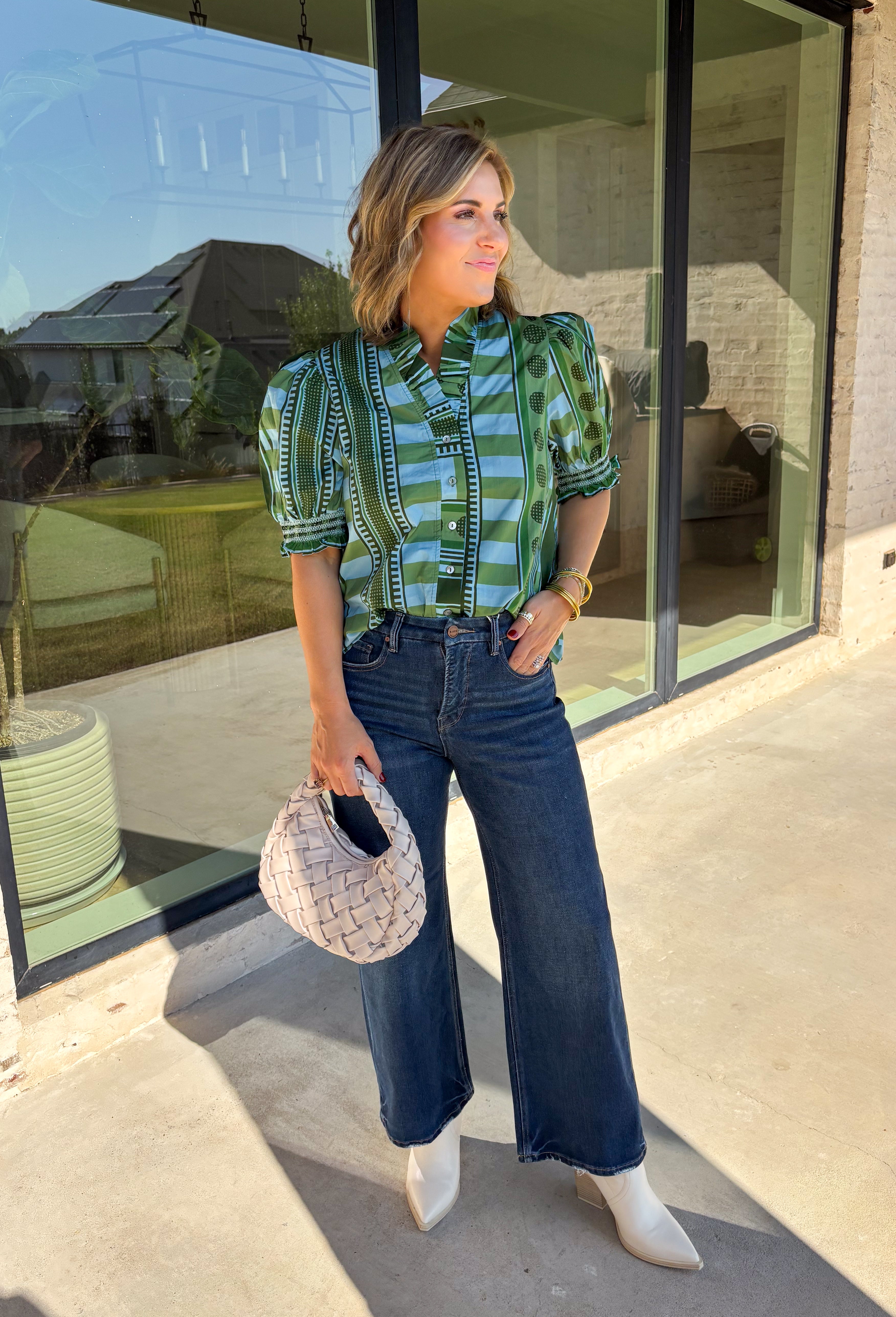 Bring playful pattern and timeless charm to your fall wardrobe with this beautifully detailed top from Entro. Featuring a unique mix of stripe and polka dot prints in rich shades of olive and blue, this eye-catching blouse is perfect for adding personality to your everyday style. The feminine ruffle neckline and button-front design create a polished look, while the short puff sleeves are finished with smocked ruffle cuffs for an extra touch of charm. 