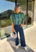 Bring playful pattern and timeless charm to your fall wardrobe with this beautifully detailed top from Entro. Featuring a unique mix of stripe and polka dot prints in rich shades of olive and blue, this eye-catching blouse is perfect for adding personality to your everyday style. The feminine ruffle neckline and button-front design create a polished look, while the short puff sleeves are finished with smocked ruffle cuffs for an extra touch of charm. 