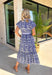 Fresh, charming, and full of thoughtful details, this blue button-down midi dress by Entro feels like spring in dress form. Featuring an off-white floral print with delicate mini star accents throughout, it strikes the perfect balance between playful and classic. The blue and white striped collar and trim add a crisp contrast, while the matching self-tie waist creates a flattering, easy fit. 