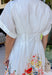 Fresh, timeless, and full of spring color, this white button-down midi dress by Entro is an instant favorite. The clean white base keeps it classic, while the colorful floral print along the bottom adds the prettiest pop of color—featuring shades of orange, red, yellow, pink, blue, and green. Cuffed sleeves give it an easy, relaxed feel, and pleating detail along the front adds a flattering touch that elevates the whole look. 