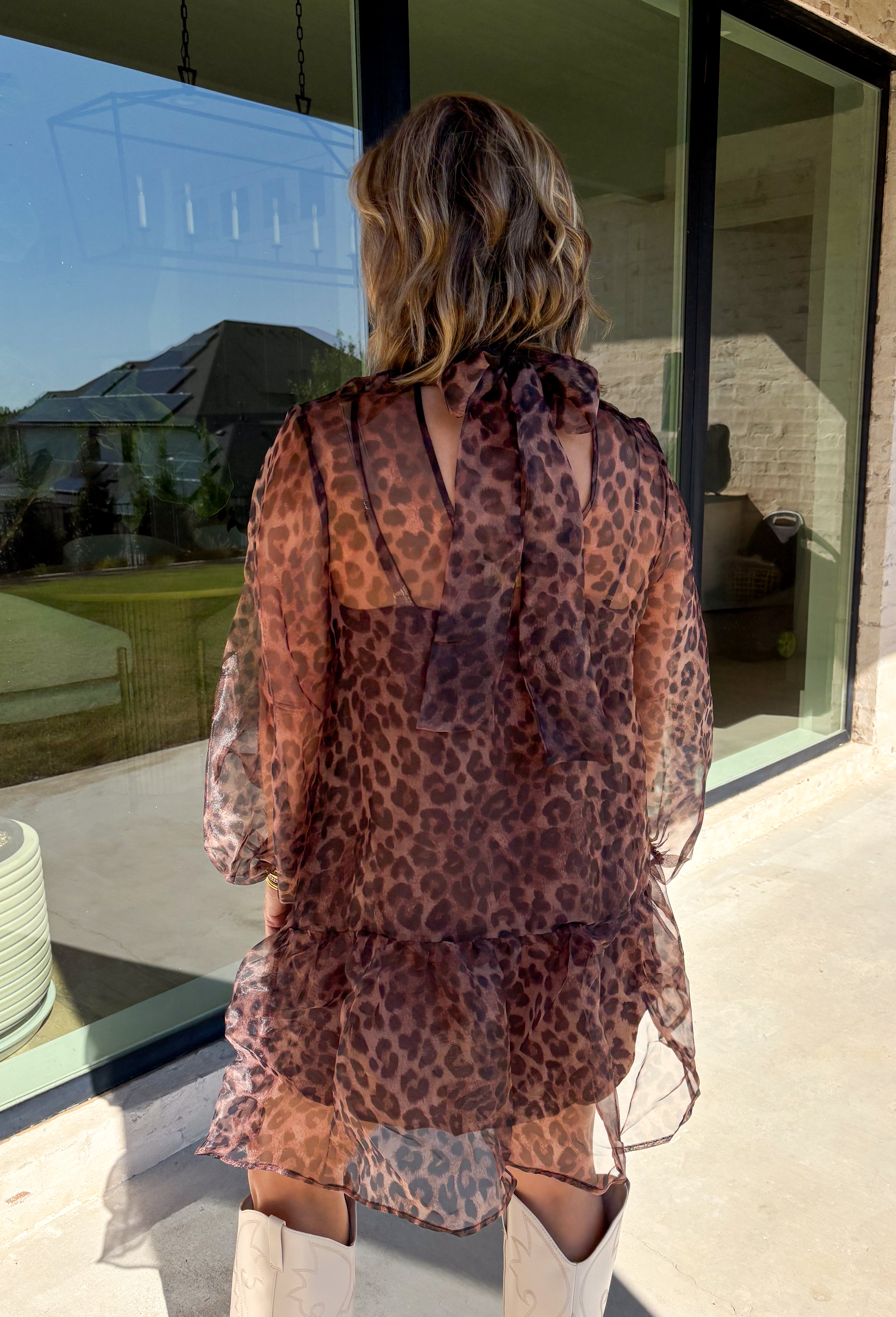 Turn up the print with this leopard dress from Entro, made for days when your outfit deserves a little extra personality. The classic leopard pattern pairs with a mock neckline for a put-together look, while the self-tie detail at the back adds a pretty finishing touch. Long balloon sleeves create soft volume and are finished with elastic cuffs for a comfortable fit. A playful ruffle hem adds movement to the shorter silhouette, and the lined design provides coverage beneath the semi-sheer woven fabric.