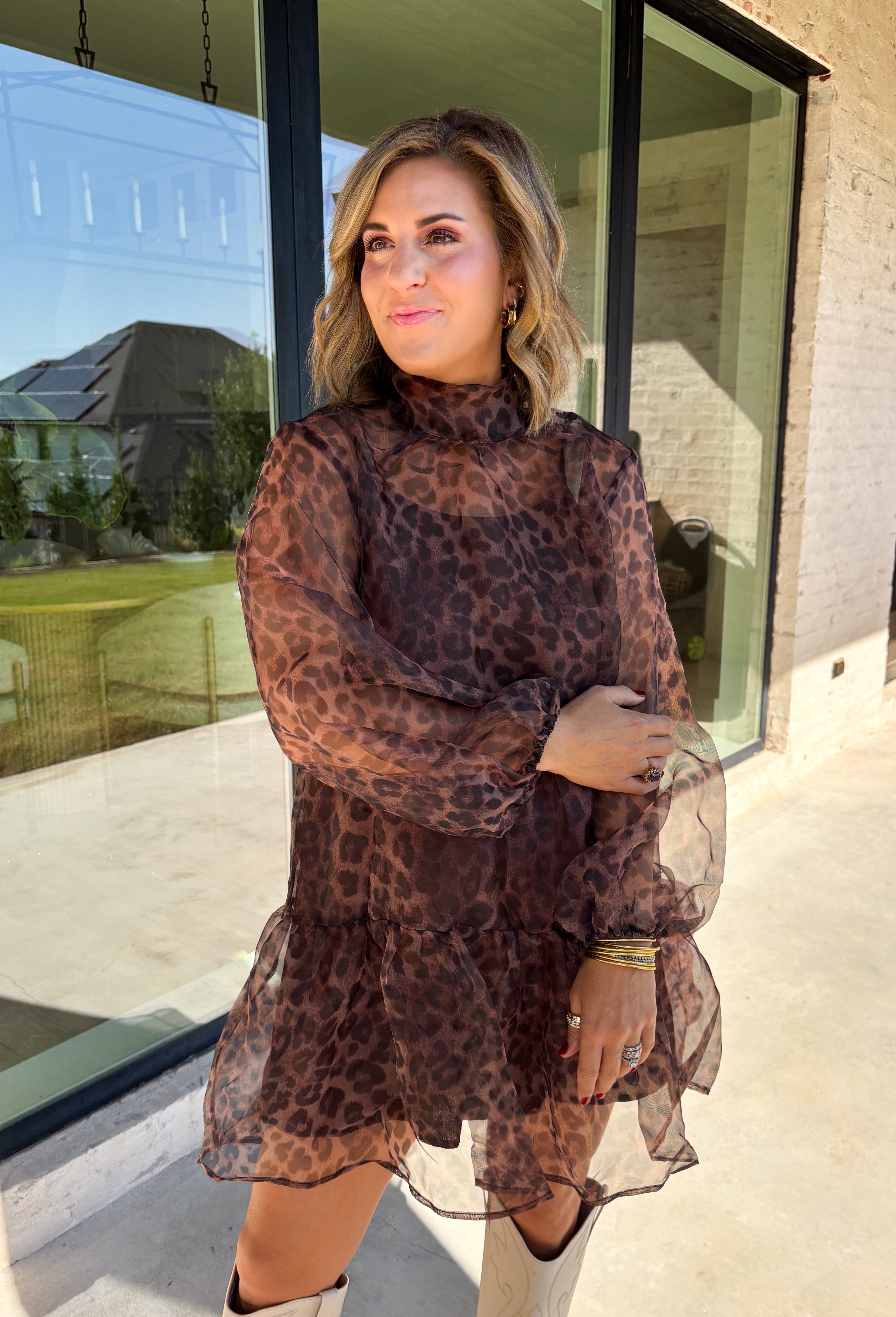 Turn up the print with this leopard dress from Entro, made for days when your outfit deserves a little extra personality. The classic leopard pattern pairs with a mock neckline for a put-together look, while the self-tie detail at the back adds a pretty finishing touch. Long balloon sleeves create soft volume and are finished with elastic cuffs for a comfortable fit. A playful ruffle hem adds movement to the shorter silhouette, and the lined design provides coverage beneath the semi-sheer woven fabric.