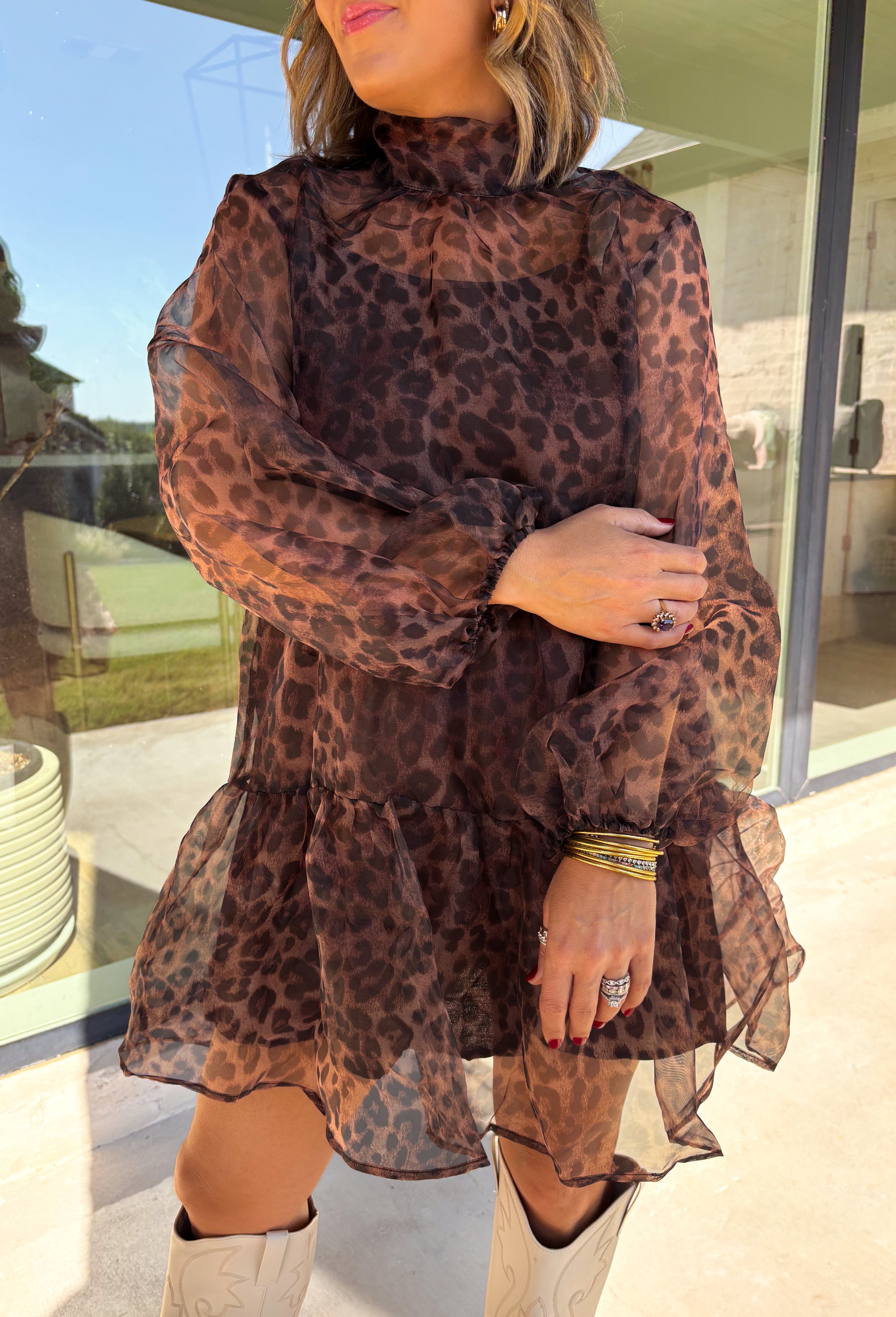 Turn up the print with this leopard dress from Entro, made for days when your outfit deserves a little extra personality. The classic leopard pattern pairs with a mock neckline for a put-together look, while the self-tie detail at the back adds a pretty finishing touch. Long balloon sleeves create soft volume and are finished with elastic cuffs for a comfortable fit. A playful ruffle hem adds movement to the shorter silhouette, and the lined design provides coverage beneath the semi-sheer woven fabric.