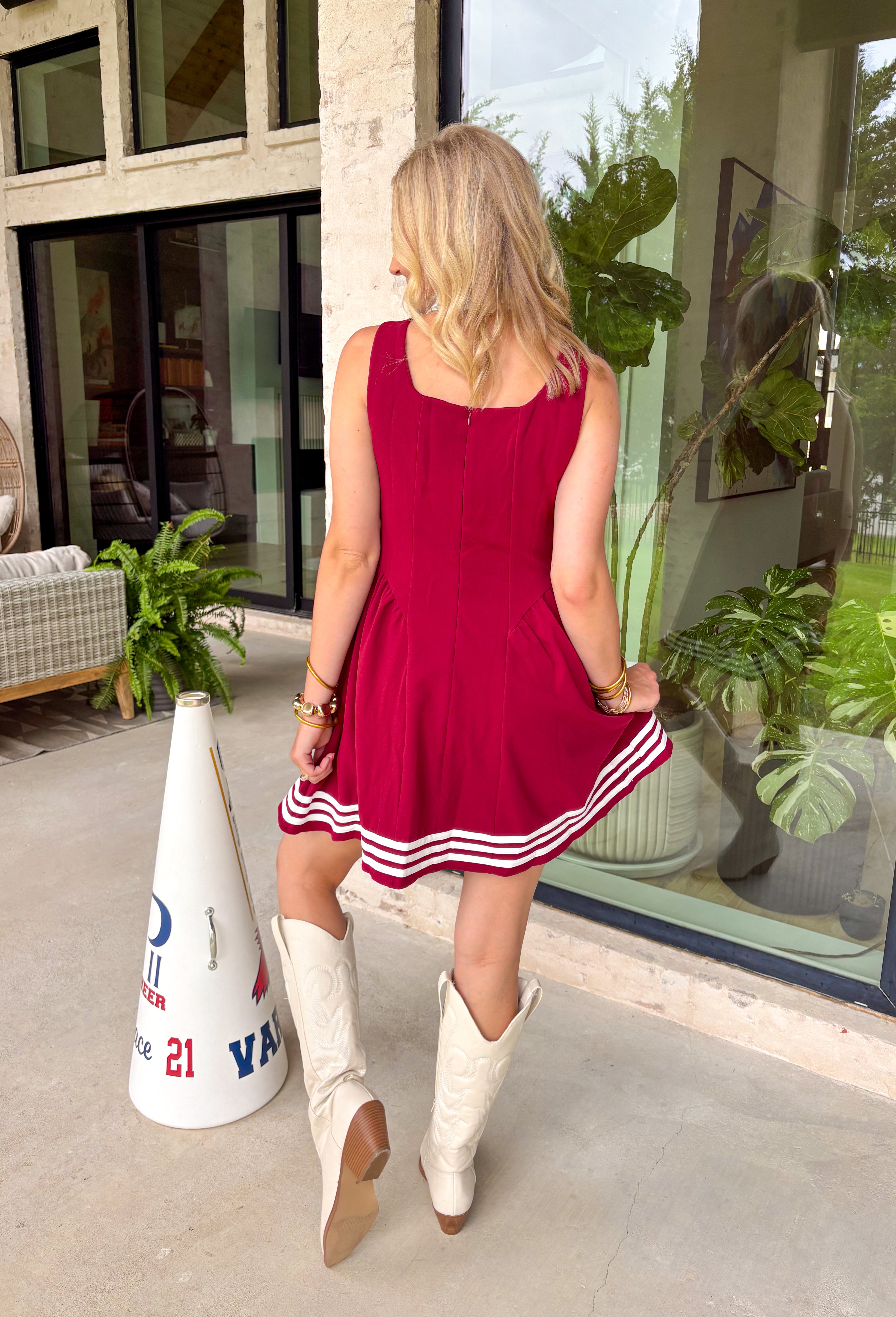 Football season just got a whole lot cuter! This garnet sleeveless dress is the perfect game day pick, featuring crisp white trim along the bottom for a classic contrast that stands out in the crowd. The easy silhouette makes it comfortable enough for tailgates, watch parties, and cheering from the stands, while the fully lined design keeps it feeling polished and put together. 