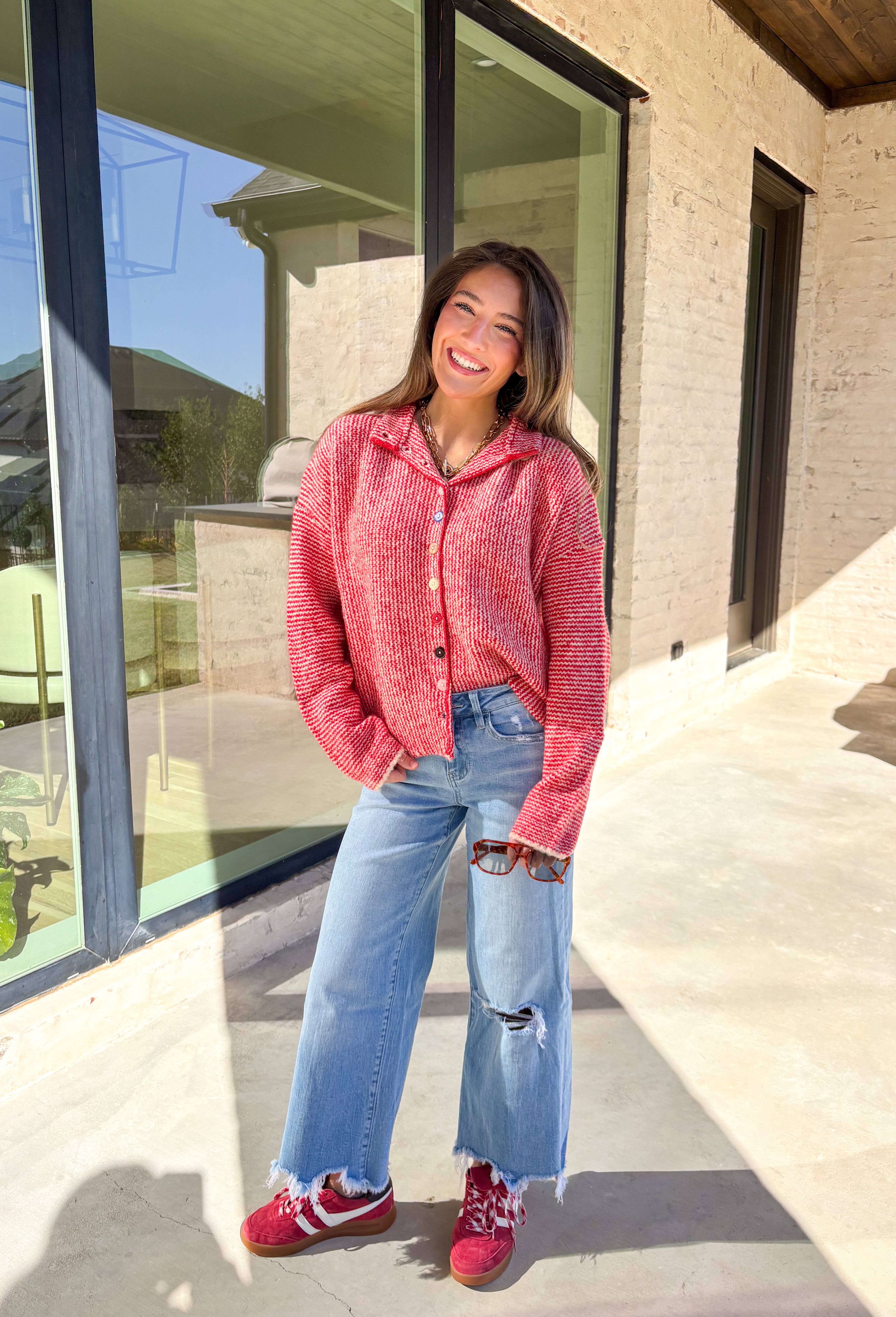 Cozy meets classic in this red and white mini chevron knit cardigan by &amp;Merci. Designed with a mock neck and colorful button-down front, this sweater brings a fun twist to a timeless winter look. The soft knit texture and warm tones make it the perfect layer for chilly days!