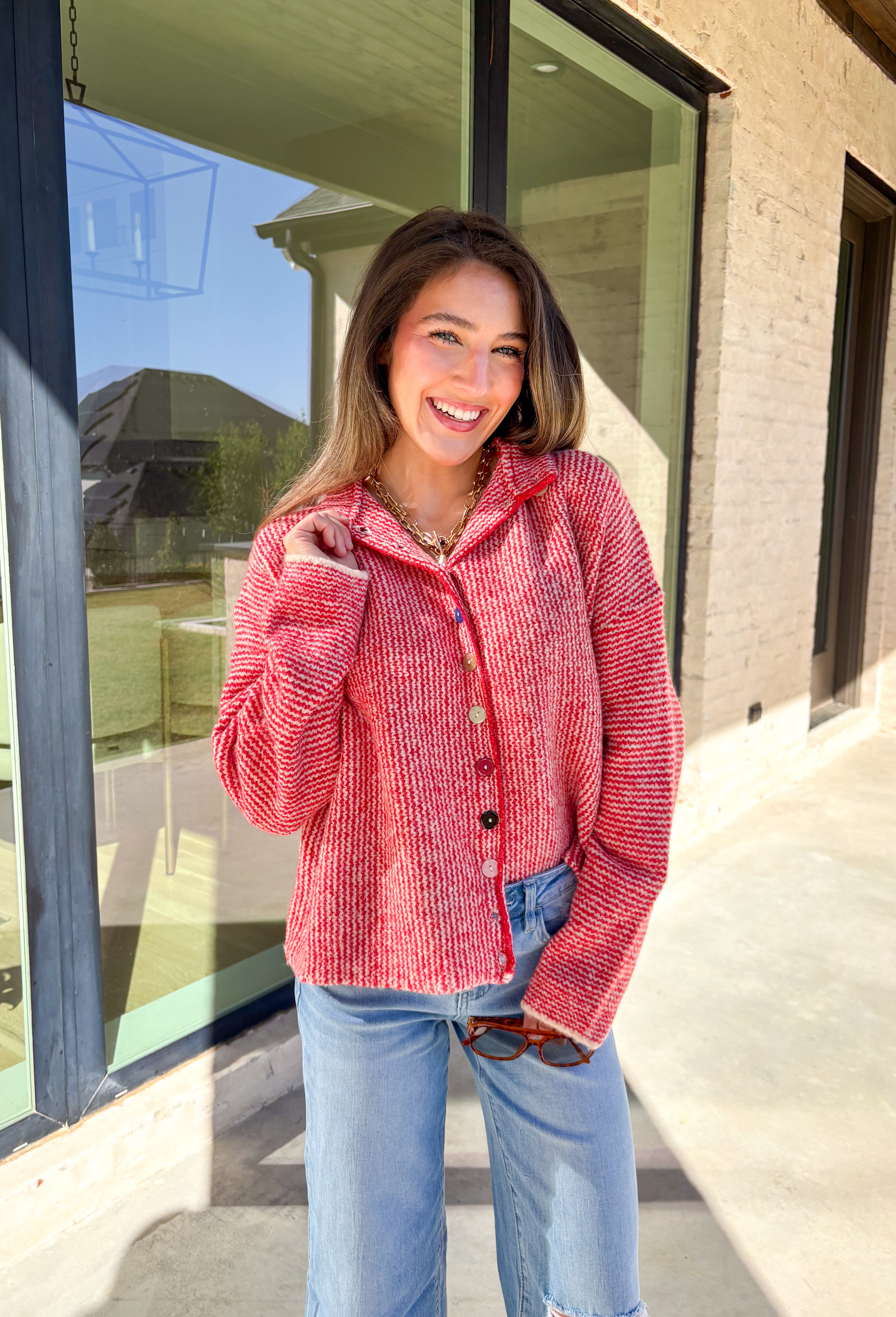 Cozy meets classic in this red and white mini chevron knit cardigan by &amp;Merci. Designed with a mock neck and colorful button-down front, this sweater brings a fun twist to a timeless winter look. The soft knit texture and warm tones make it the perfect layer for chilly days!
