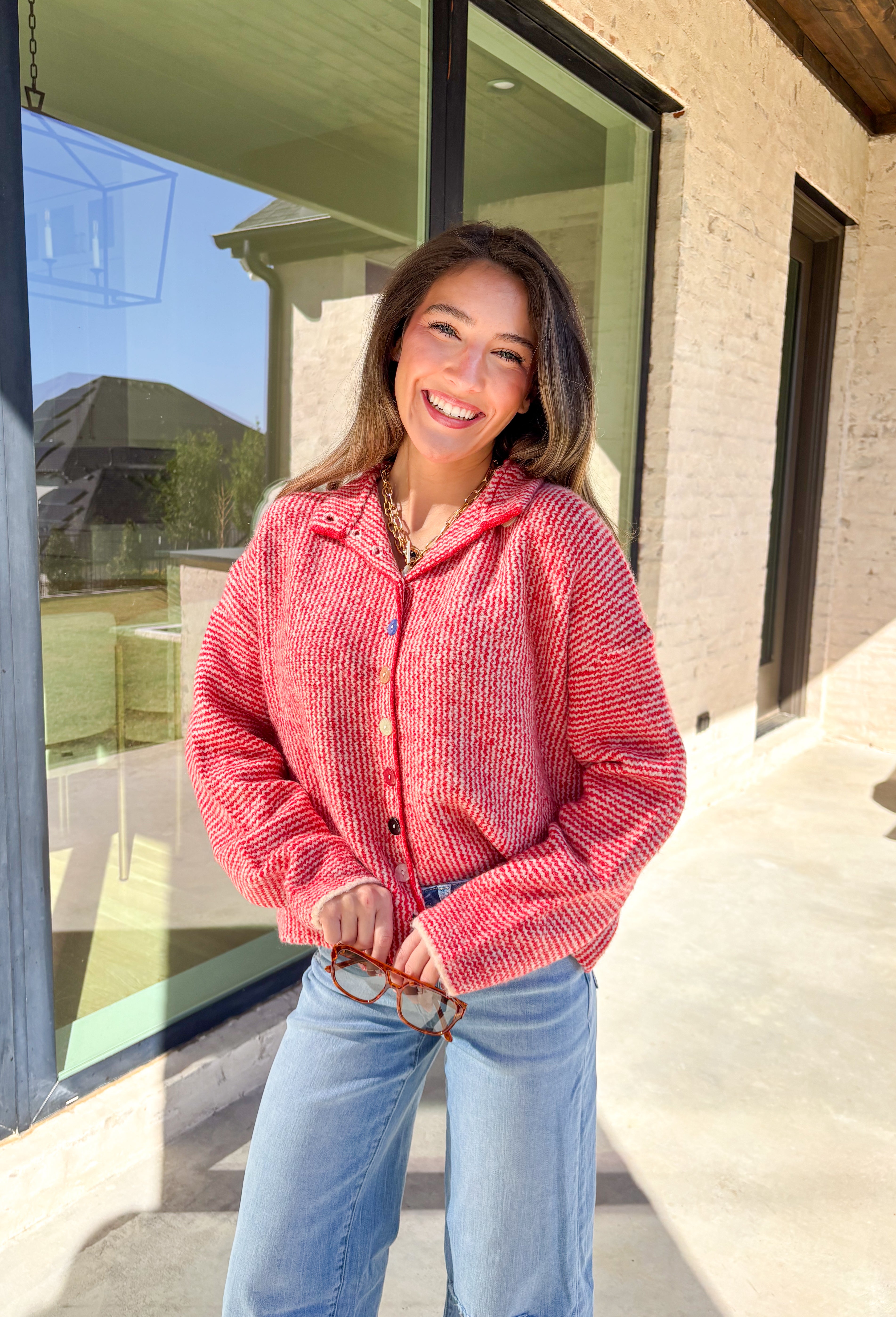 Cozy meets classic in this red and white mini chevron knit cardigan by &amp;Merci. Designed with a mock neck and colorful button-down front, this sweater brings a fun twist to a timeless winter look. The soft knit texture and warm tones make it the perfect layer for chilly days!