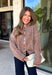 Cozy meets classic in this brown and taupe mini chevron knit cardigan by &Merci. The playful chevron pattern gives this sweater a fun, vintage-inspired feel, while the colorful button-down front adds an unexpected pop of personality. Designed with a mock neckline and a soft, cozy knit texture, it’s perfect for keeping warm when the temperatures start to drop. The classic brown and taupe color combination makes it an easy choice for winter days, holiday outings, and casual weekends. 