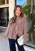 Cozy meets classic in this brown and taupe mini chevron knit cardigan by &Merci. The playful chevron pattern gives this sweater a fun, vintage-inspired feel, while the colorful button-down front adds an unexpected pop of personality. Designed with a mock neckline and a soft, cozy knit texture, it’s perfect for keeping warm when the temperatures start to drop. The classic brown and taupe color combination makes it an easy choice for winter days, holiday outings, and casual weekends. 