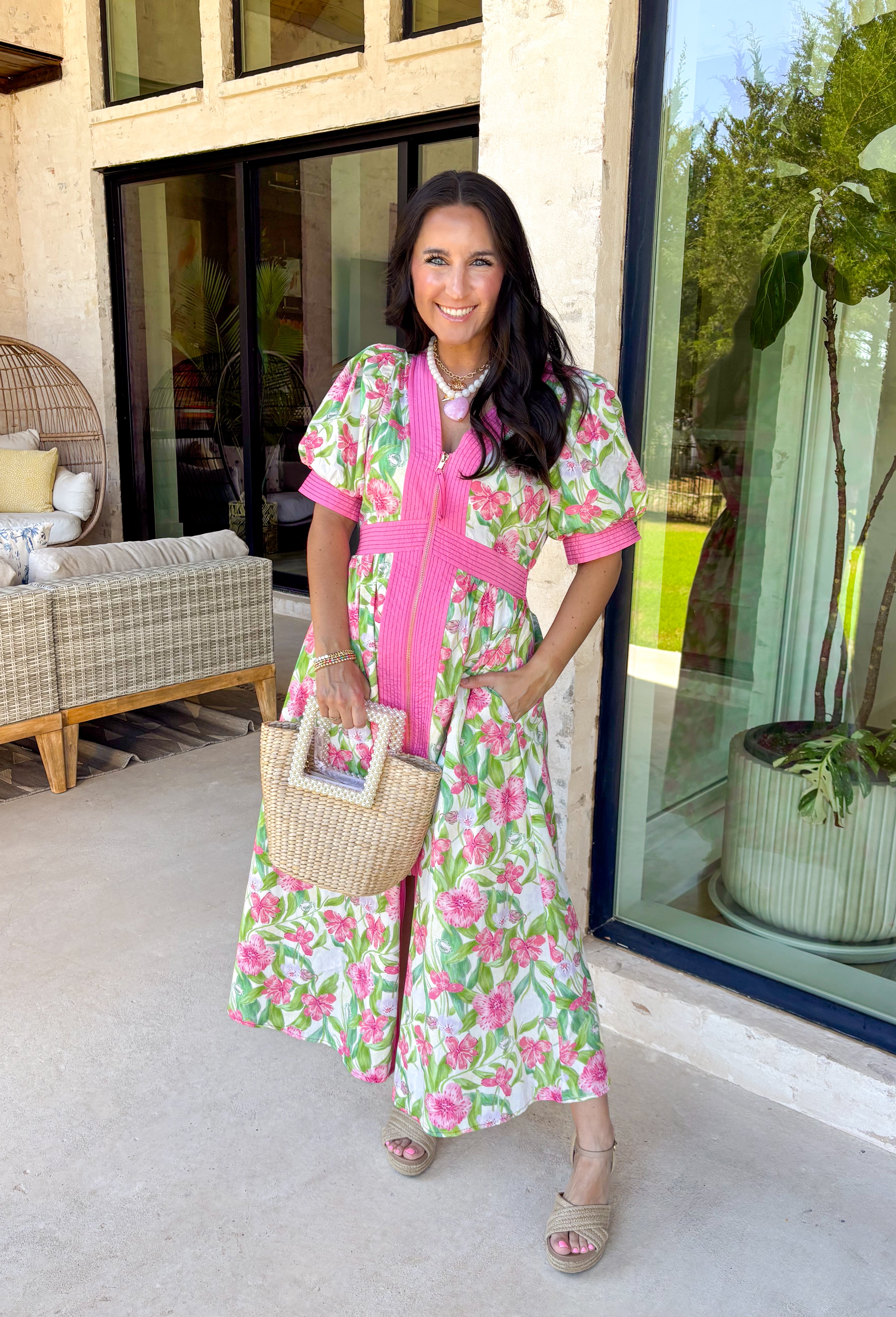Fresh, flattering, and made for spring days, this off-white midi dress is an easy standout. Featuring a green and pink floral print throughout, it feels bright and cheerful, while the pink trim adds the sweetest pop of contrast. The front zipper closure gives it a modern touch, and the front slit makes it easy to move (and adds a little extra flair). 