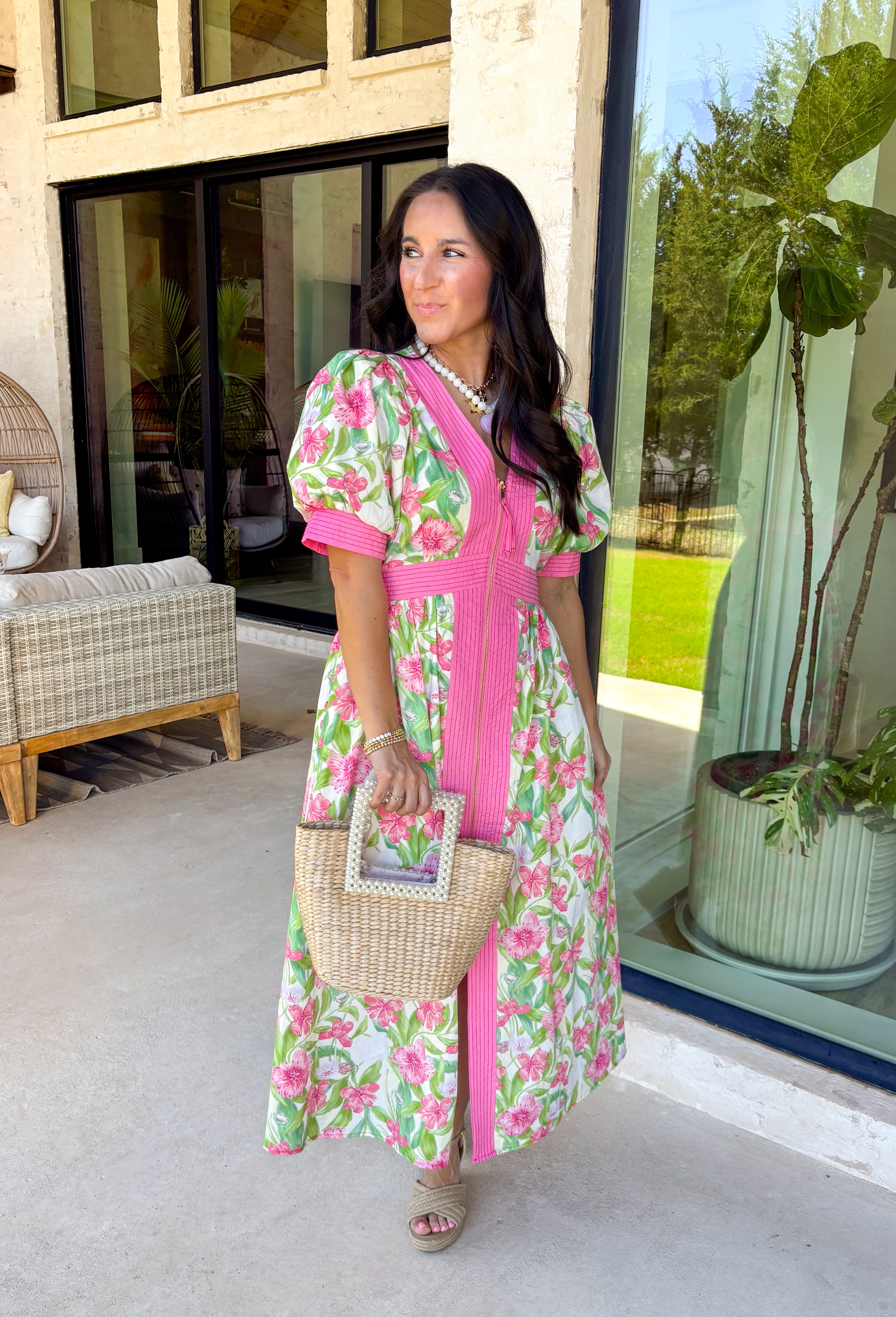 Fresh, flattering, and made for spring days, this off-white midi dress is an easy standout. Featuring a green and pink floral print throughout, it feels bright and cheerful, while the pink trim adds the sweetest pop of contrast. The front zipper closure gives it a modern touch, and the front slit makes it easy to move (and adds a little extra flair). 