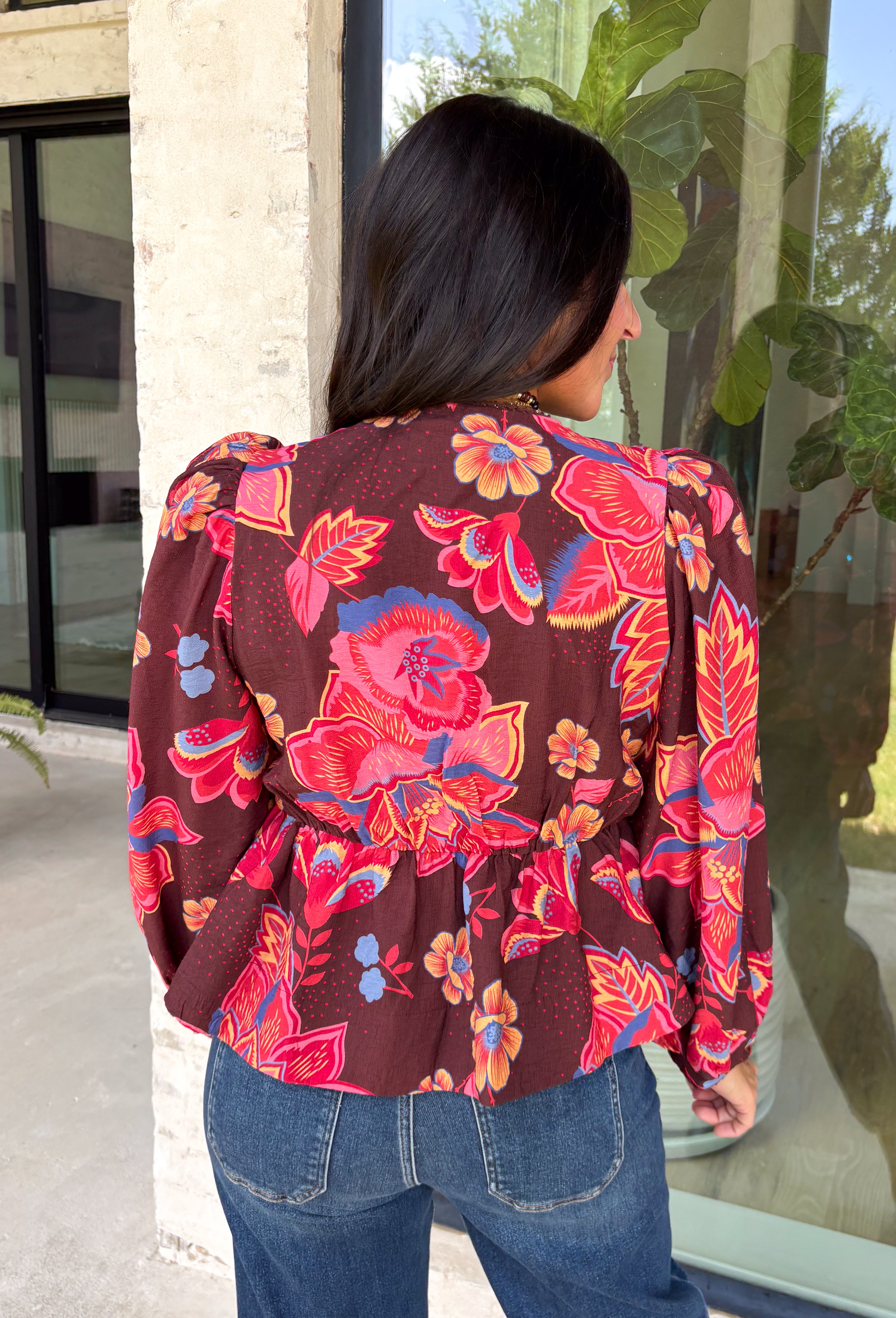 Rich autumn color and pretty details come together in this floral blouse from Entro. The warm brown background is covered in a fall-inspired floral print, making it an easy way to bring the colors of the season into your everyday wardrobe. A v-neckline and button-front closure keep the silhouette classic, while scalloped trim along the neckline and sleeve cuffs adds a sweet finishing touch. 