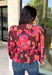 Rich autumn color and pretty details come together in this floral blouse from Entro. The warm brown background is covered in a fall-inspired floral print, making it an easy way to bring the colors of the season into your everyday wardrobe. A v-neckline and button-front closure keep the silhouette classic, while scalloped trim along the neckline and sleeve cuffs adds a sweet finishing touch. 