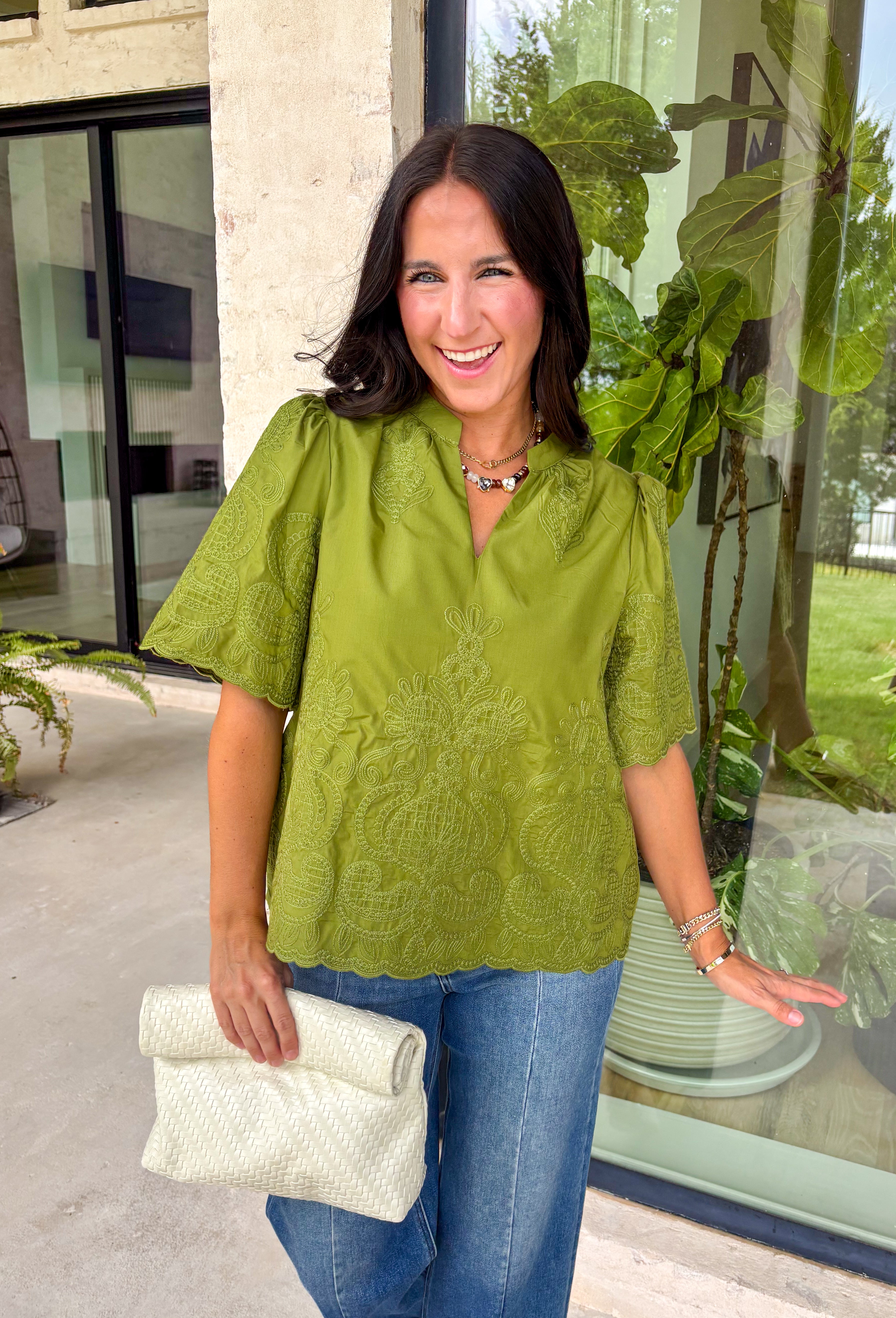 Classic details and rich autumn color come together beautifully in this effortlessly feminine blouse. Designed in a gorgeous olive green hue, this top features delicate embroidery that adds texture and timeless charm without overwhelming the look. The split neckline and puff sleeves create an elevated silhouette, while the scalloped trim along the hem and sleeve openings adds a sweet finishing touch. 