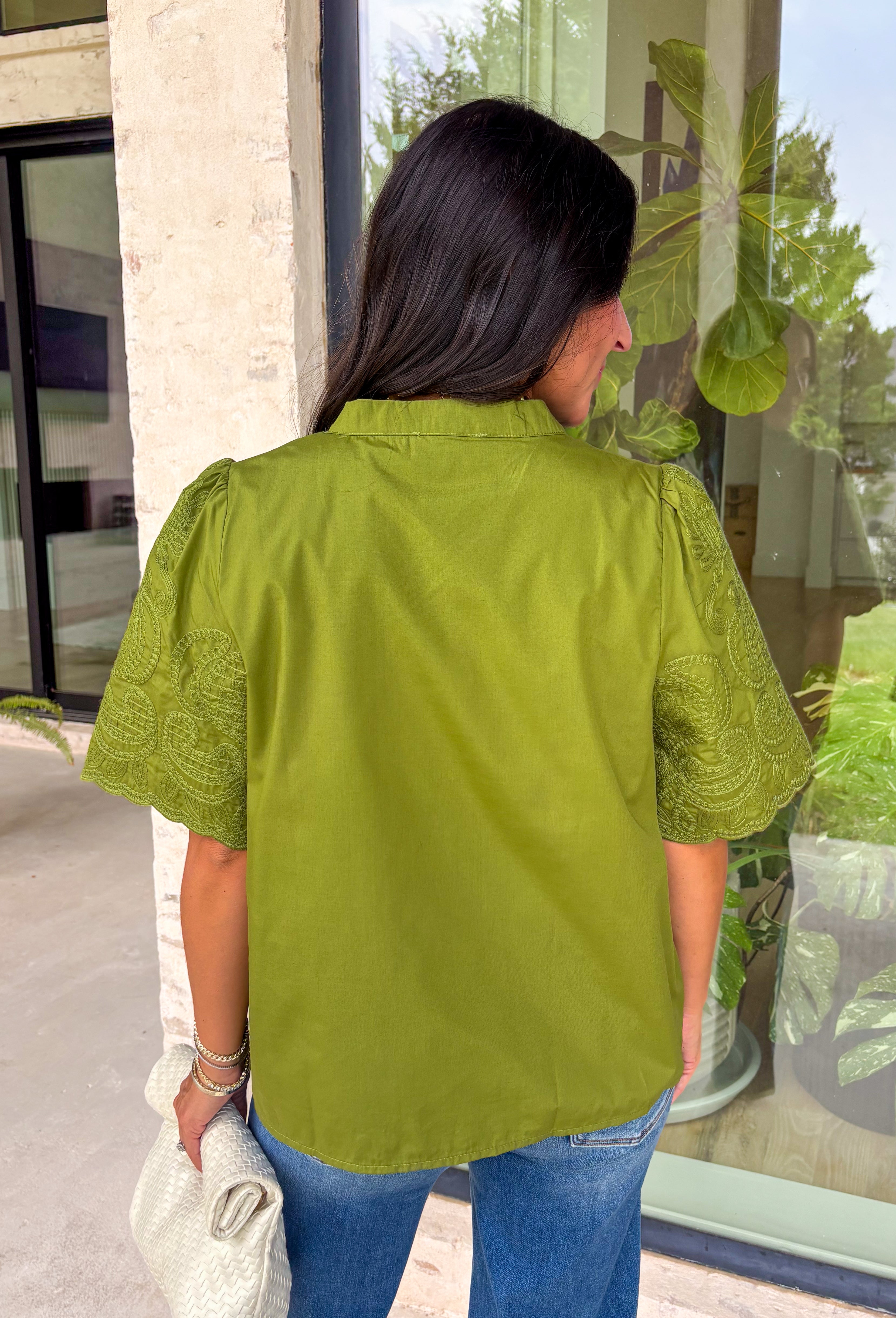 Classic details and rich autumn color come together beautifully in this effortlessly feminine blouse. Designed in a gorgeous olive green hue, this top features delicate embroidery that adds texture and timeless charm without overwhelming the look. The split neckline and puff sleeves create an elevated silhouette, while the scalloped trim along the hem and sleeve openings adds a sweet finishing touch. 