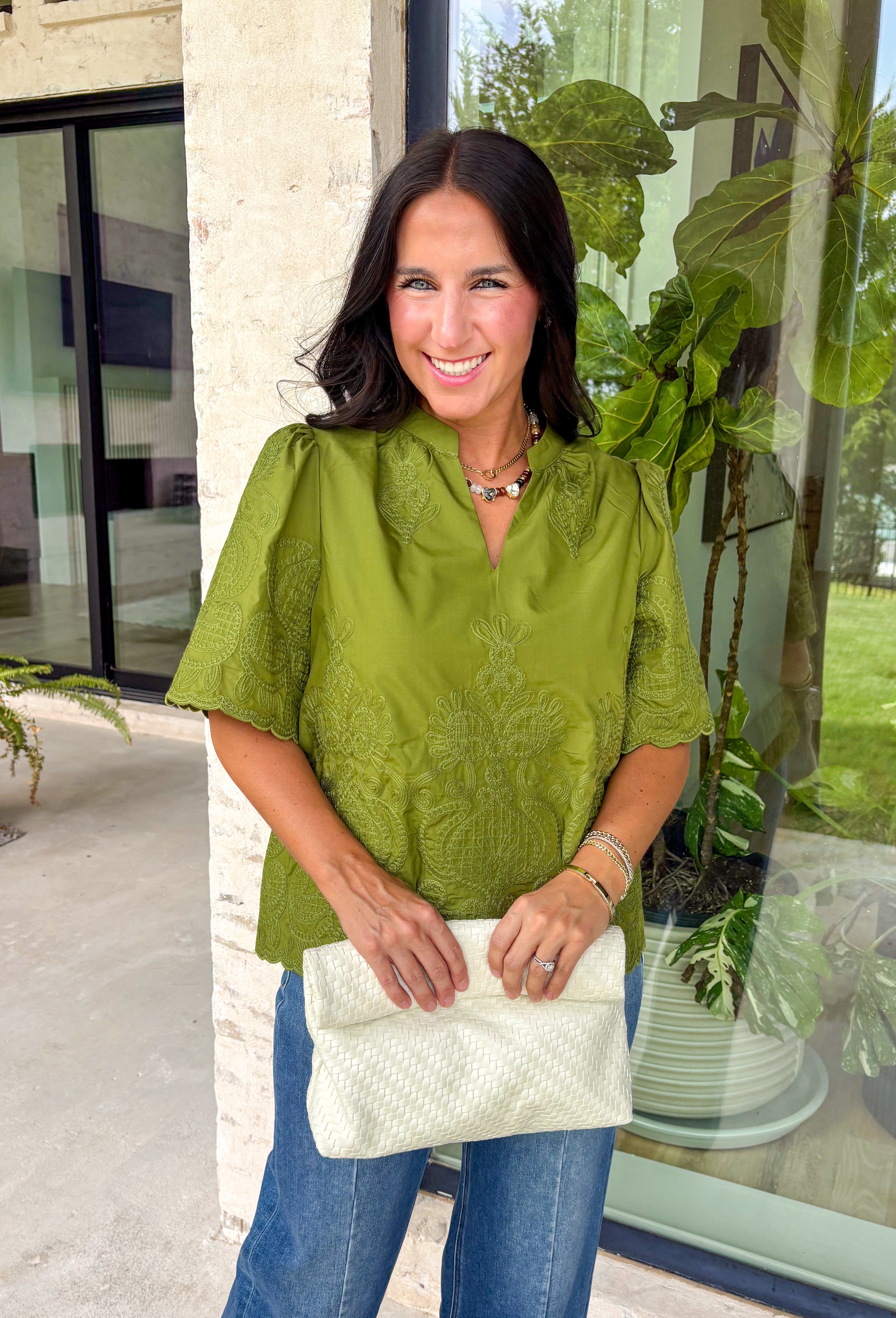 Classic details and rich autumn color come together beautifully in this effortlessly feminine blouse. Designed in a gorgeous olive green hue, this top features delicate embroidery that adds texture and timeless charm without overwhelming the look. The split neckline and puff sleeves create an elevated silhouette, while the scalloped trim along the hem and sleeve openings adds a sweet finishing touch. 