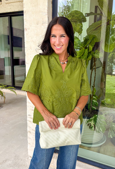 Classic details and rich autumn color come together beautifully in this effortlessly feminine blouse. Designed in a gorgeous olive green hue, this top features delicate embroidery that adds texture and timeless charm without overwhelming the look. The split neckline and puff sleeves create an elevated silhouette, while the scalloped trim along the hem and sleeve openings adds a sweet finishing touch. 