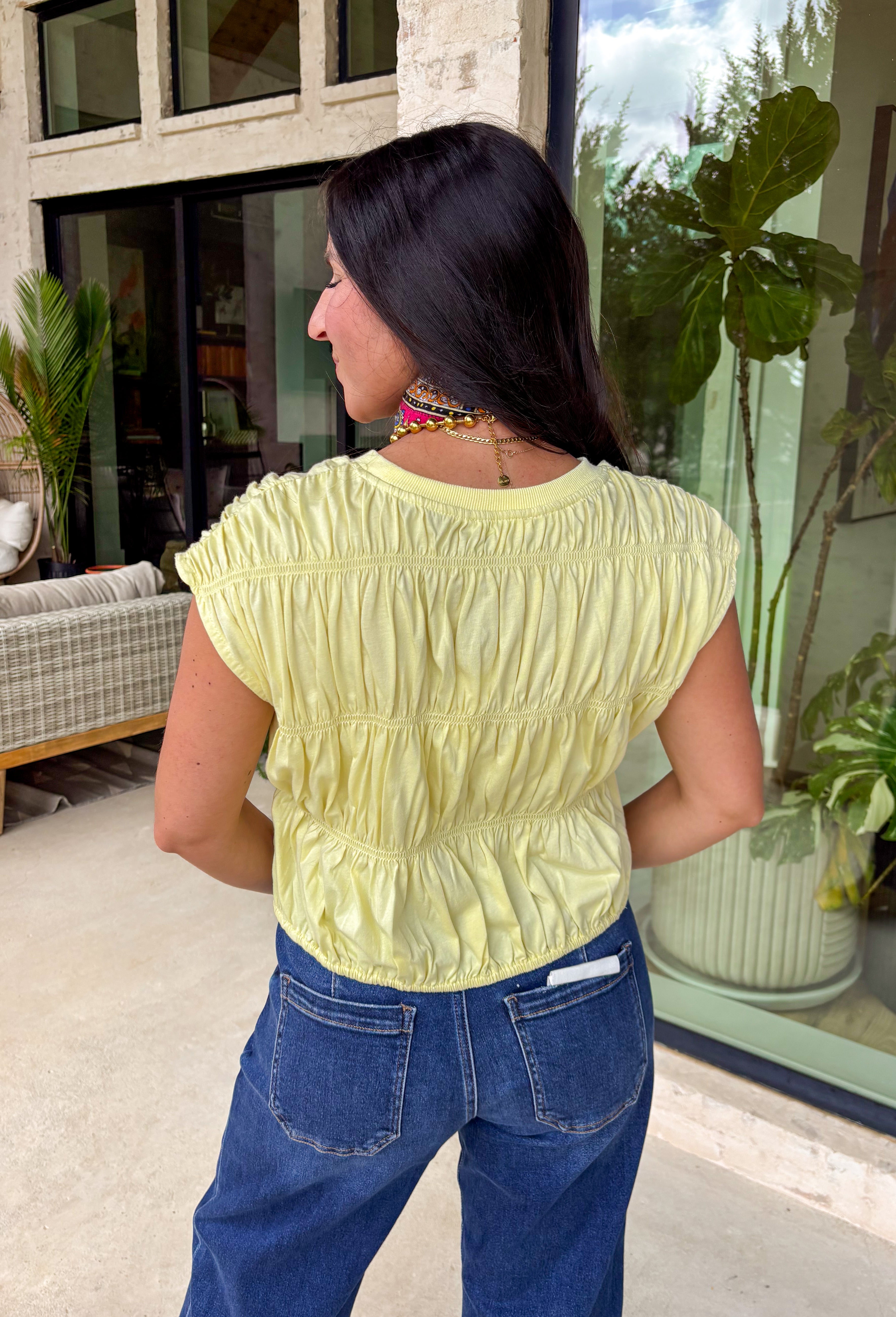 Say hello to your new sunshine staple! This butter yellow short sleeve top is giving all the happy, fresh vibes with its tiered peplum silhouette and delicate shirred detailing throughout. The lightweight, textured cotton keeps it breathable and easy to wear, while the cropped length and elastic hem create a flattering shape that pairs perfectly with high-rise denim. It’s playful, feminine, and made for warm days when you want something effortless but still extra cute.