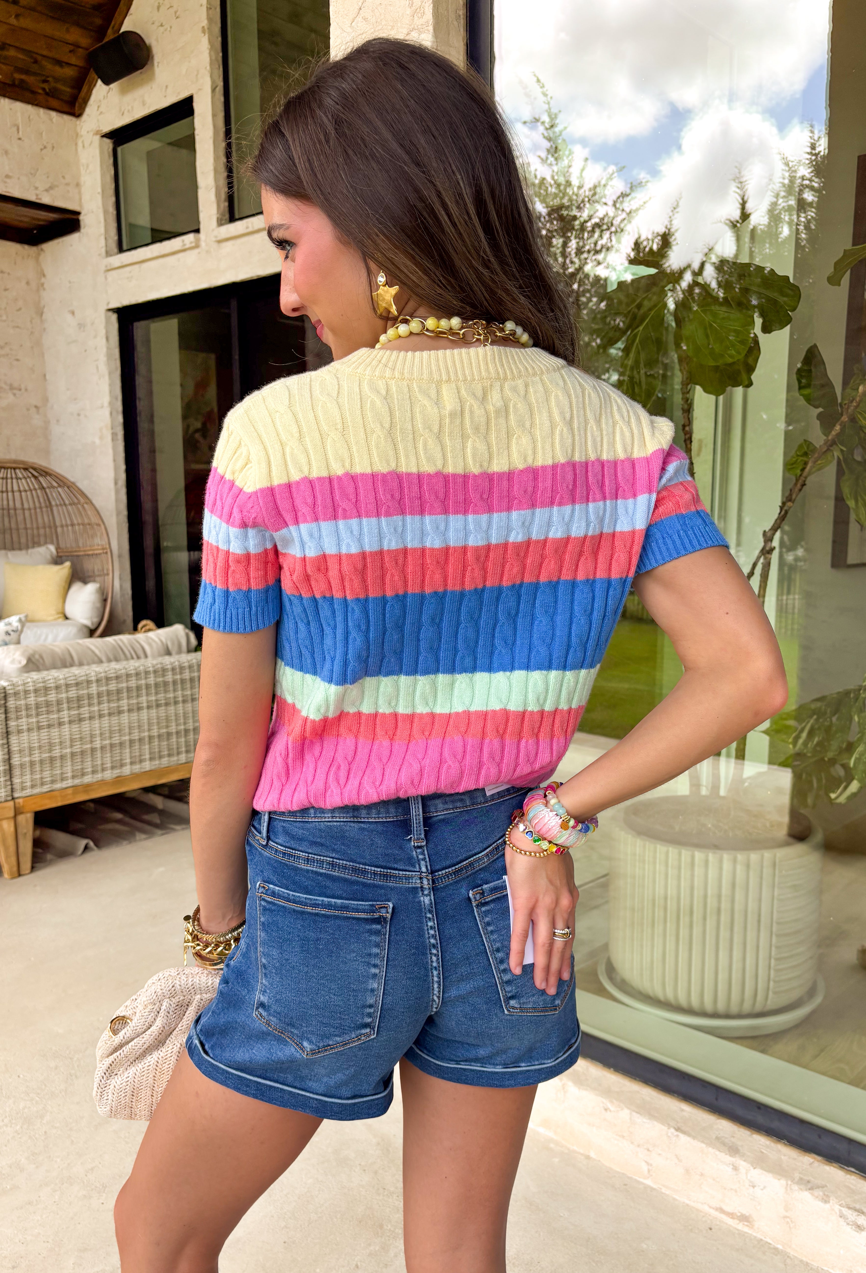Bright, bold, and guaranteed to boost your mood! This short sleeve cable knit sweater features a fun color block design in cheerful shades of yellow, pink, blue, coral, and green. It’s playful, eye-catching, and perfect for adding a pop of color to your everyday look. The cable knit texture adds a classic touch, while the lightweight feel keeps it easy to wear through the season. It’s the kind of piece that makes getting dressed feel fun again.