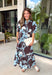 Celebrate the beauty of the season in this effortlessly feminine floral midi dress. Featuring a rich brown backdrop with a bold light blue and white floral print, this timeless silhouette is perfect for everything from weekend brunches to holiday gatherings. The ruffle neckline, puff sleeves, and flowy ruffle hem add a soft, romantic touch, while the button-front design creates a classic look you'll wear year after year. 