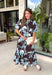 Celebrate the beauty of the season in this effortlessly feminine floral midi dress. Featuring a rich brown backdrop with a bold light blue and white floral print, this timeless silhouette is perfect for everything from weekend brunches to holiday gatherings. The ruffle neckline, puff sleeves, and flowy ruffle hem add a soft, romantic touch, while the button-front design creates a classic look you'll wear year after year. 
