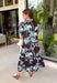 Celebrate the beauty of the season in this effortlessly feminine floral midi dress. Featuring a rich brown backdrop with a bold light blue and white floral print, this timeless silhouette is perfect for everything from weekend brunches to holiday gatherings. The ruffle neckline, puff sleeves, and flowy ruffle hem add a soft, romantic touch, while the button-front design creates a classic look you'll wear year after year. 