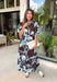 Celebrate the beauty of the season in this effortlessly feminine floral midi dress. Featuring a rich brown backdrop with a bold light blue and white floral print, this timeless silhouette is perfect for everything from weekend brunches to holiday gatherings. The ruffle neckline, puff sleeves, and flowy ruffle hem add a soft, romantic touch, while the button-front design creates a classic look you'll wear year after year. 