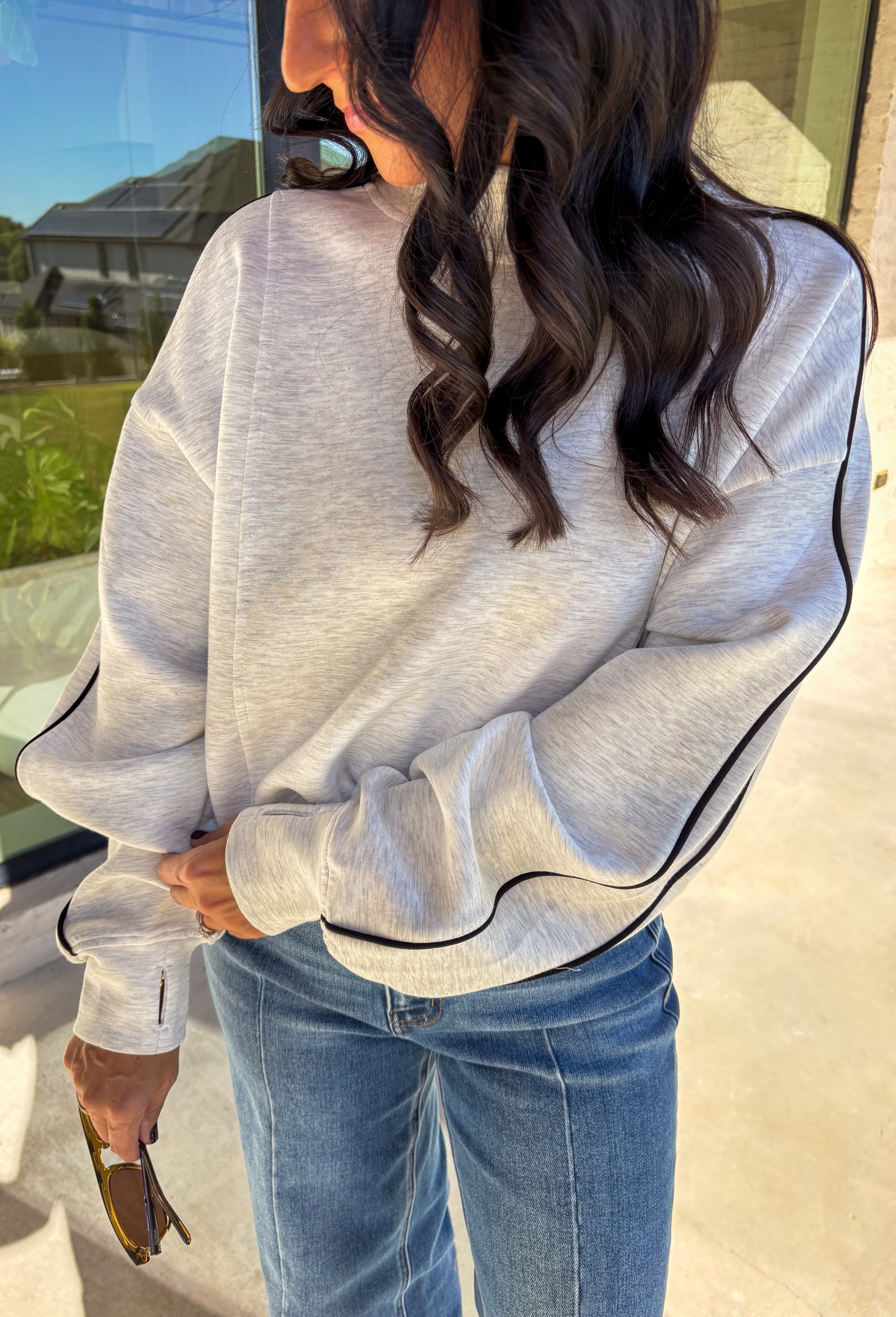 Sporty meets cozy in this heathered light gray pullover. Black stripe details run down the sleeves for a casual, athletic-inspired touch, while the soft modal-blend fabric keeps it comfortable and easy to wear all day long. With its relaxed fit and cozy feel, this piece is perfect for layering or wearing solo on cool fall days.