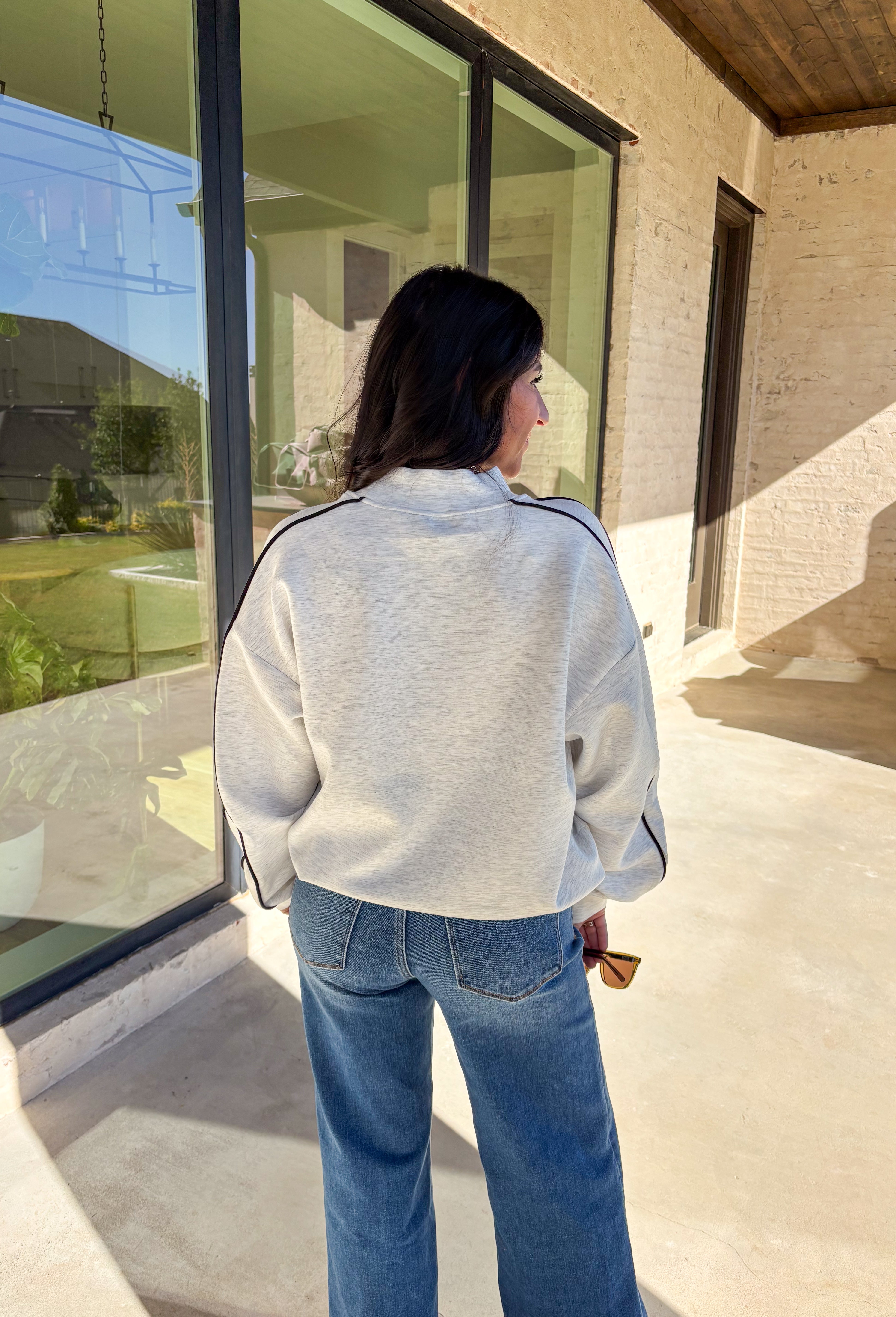 Sporty meets cozy in this heathered light gray pullover. Black stripe details run down the sleeves for a casual, athletic-inspired touch, while the soft modal-blend fabric keeps it comfortable and easy to wear all day long. With its relaxed fit and cozy feel, this piece is perfect for layering or wearing solo on cool fall days.