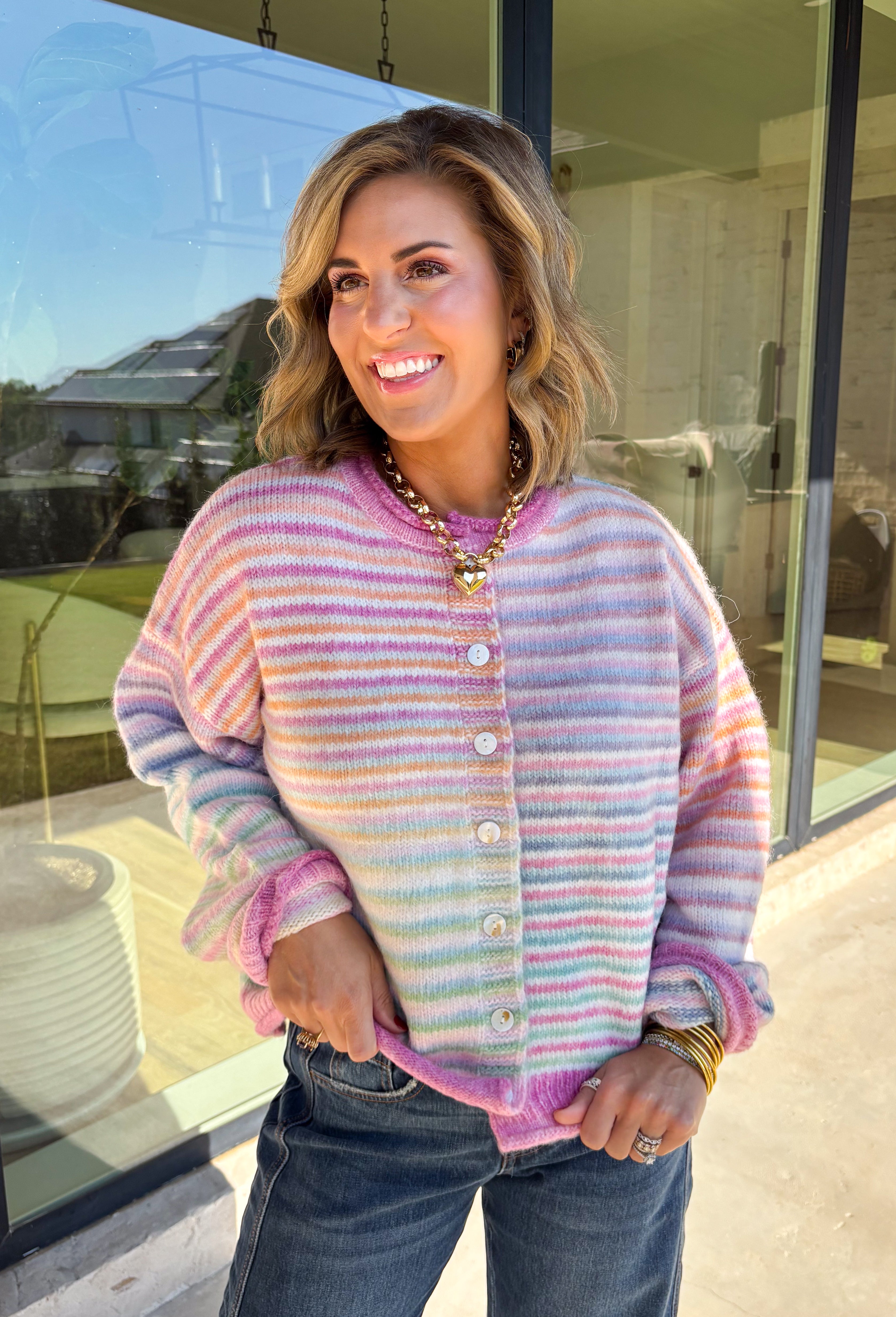 Bring a little extra color to cozy season with this striped knit cardigan from Twenitfourth. A playful mix of pink, purple, coral, blue, lavender, and off white gives this sweater a cheerful look that instantly brightens up cooler days. The button-down front makes it easy to wear closed as a top or open over your favorite tee or tank for a layered look.