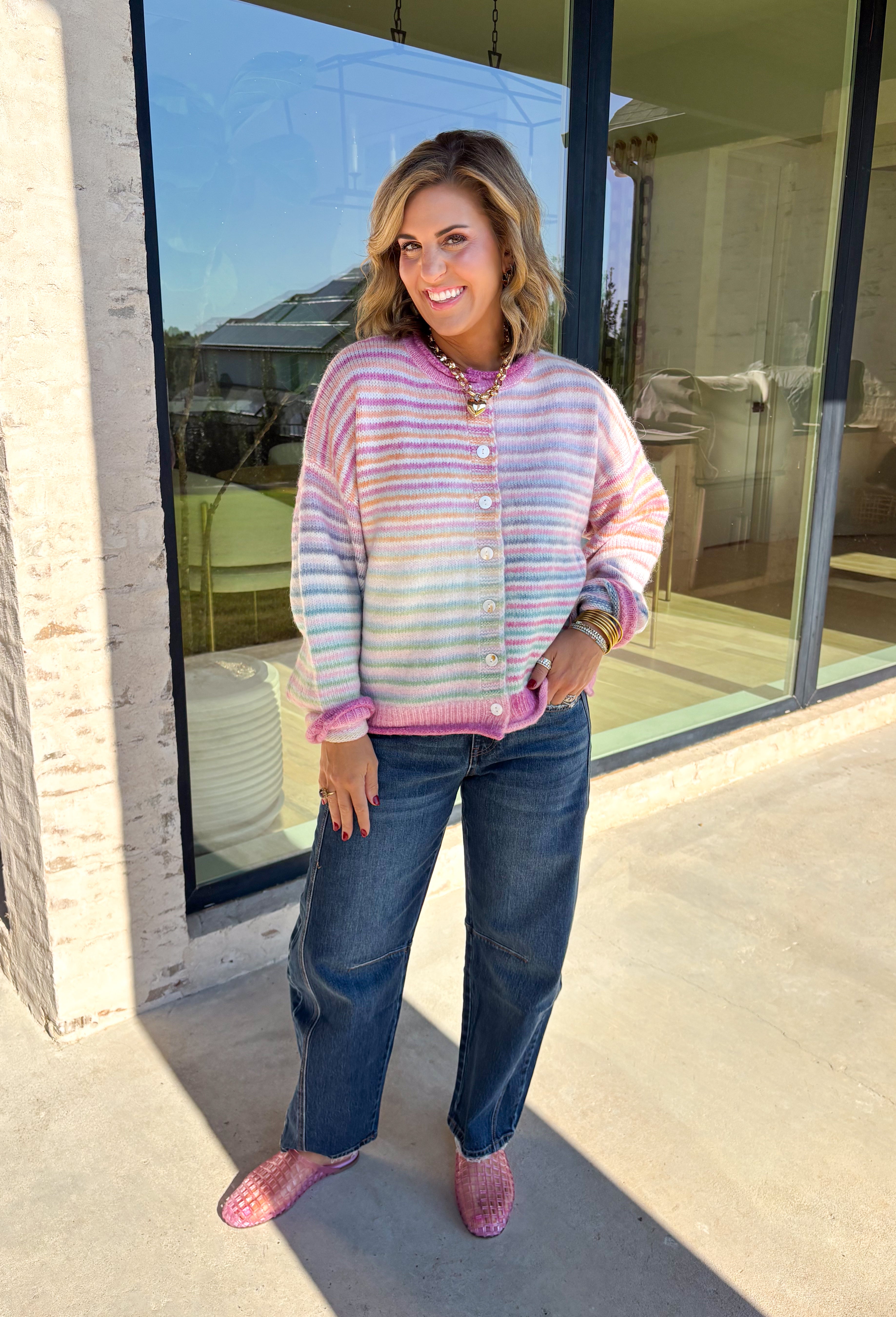 Bring a little extra color to cozy season with this striped knit cardigan from Twenitfourth. A playful mix of pink, purple, coral, blue, lavender, and off white gives this sweater a cheerful look that instantly brightens up cooler days. The button-down front makes it easy to wear closed as a top or open over your favorite tee or tank for a layered look.