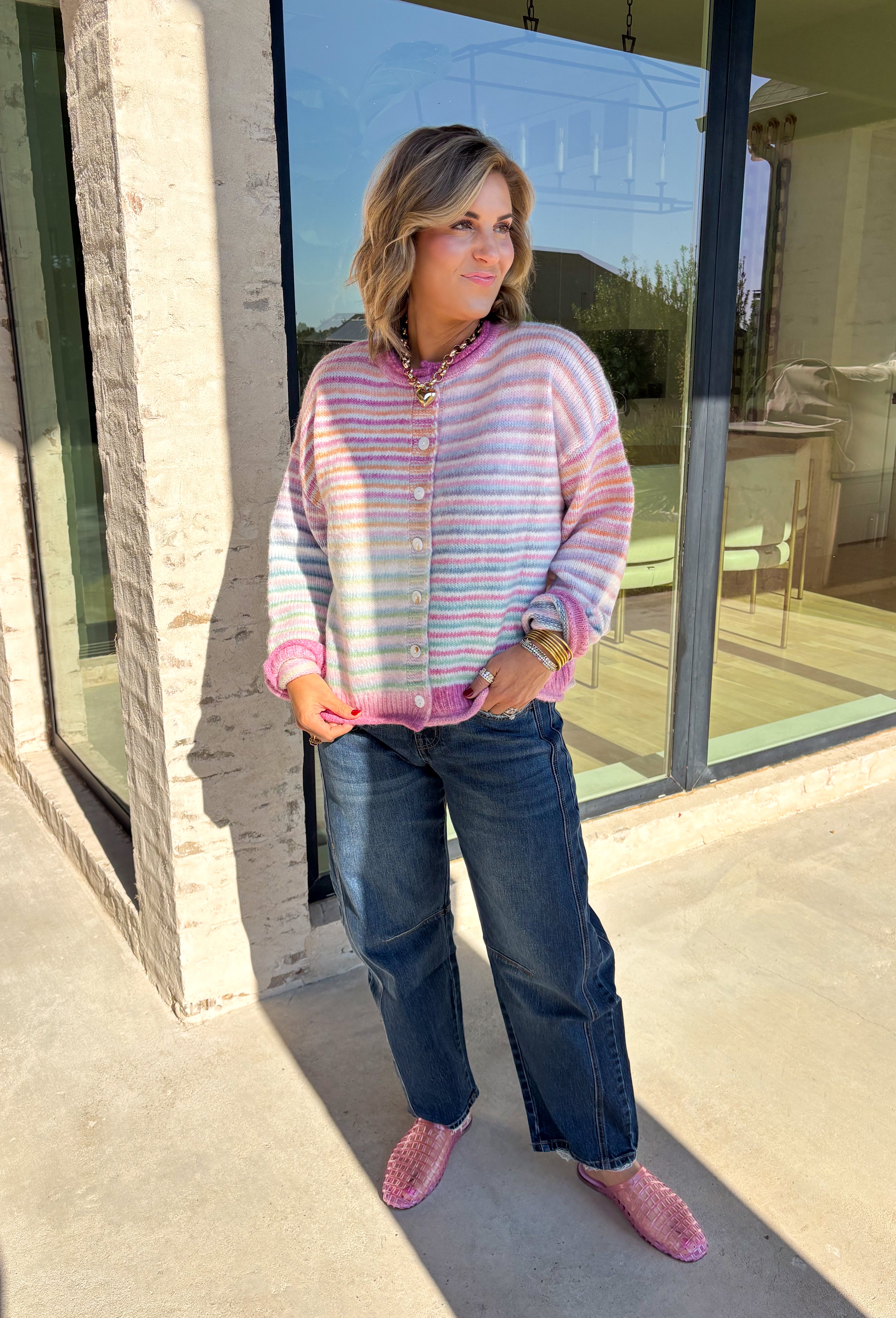 Bring a little extra color to cozy season with this striped knit cardigan from Twenitfourth. A playful mix of pink, purple, coral, blue, lavender, and off white gives this sweater a cheerful look that instantly brightens up cooler days. The button-down front makes it easy to wear closed as a top or open over your favorite tee or tank for a layered look.