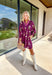 This plum floral dress is giving fall garden party—but make it chic The soft long sleeves are finished with a playful elastic ruffle, while the neutral floral print pops with dreamy shades of cream, pink, and olive. A contrasting trim along the top adds just the right amount of detail. Lined for comfort and style, it’s the kind of dress that goes from pumpkin patch strolls to dinner dates without missing a beat.