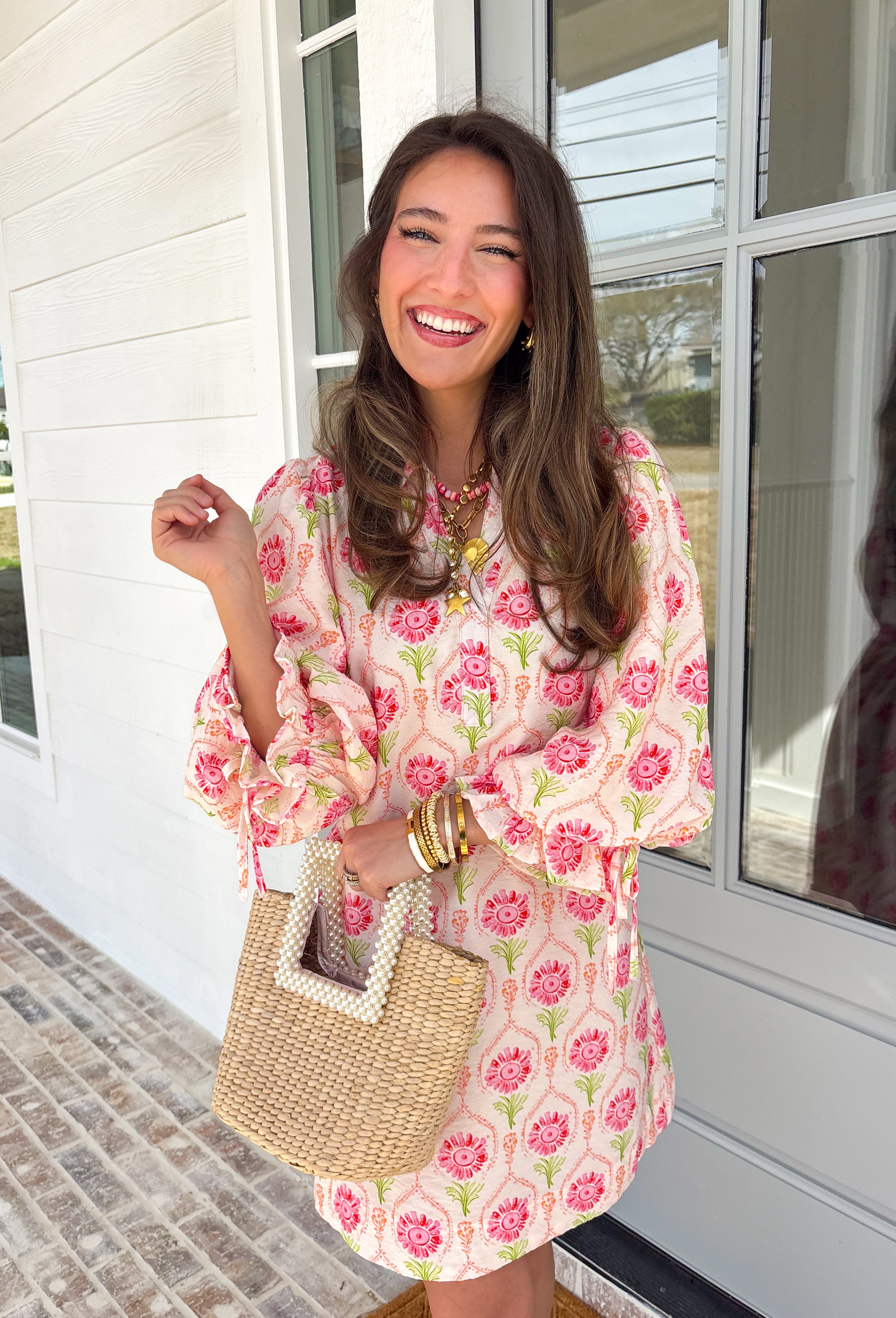 Bright, breezy, and full of spring charm, this off-white dress by Entro is an easy favorite for sunny days ahead. Featuring a colorful floral print with pops of pink, coral, and green, it feels cheerful and perfectly seasonal. The collared neckline adds a classic touch, while the ¾ length sleeves with elastic cuffs and adjustable tie details give it a relaxed, feminine finish. Fully lined for comfortable wear, this dress is effortlessly polished and ready for everything from brunch dates to spring events.