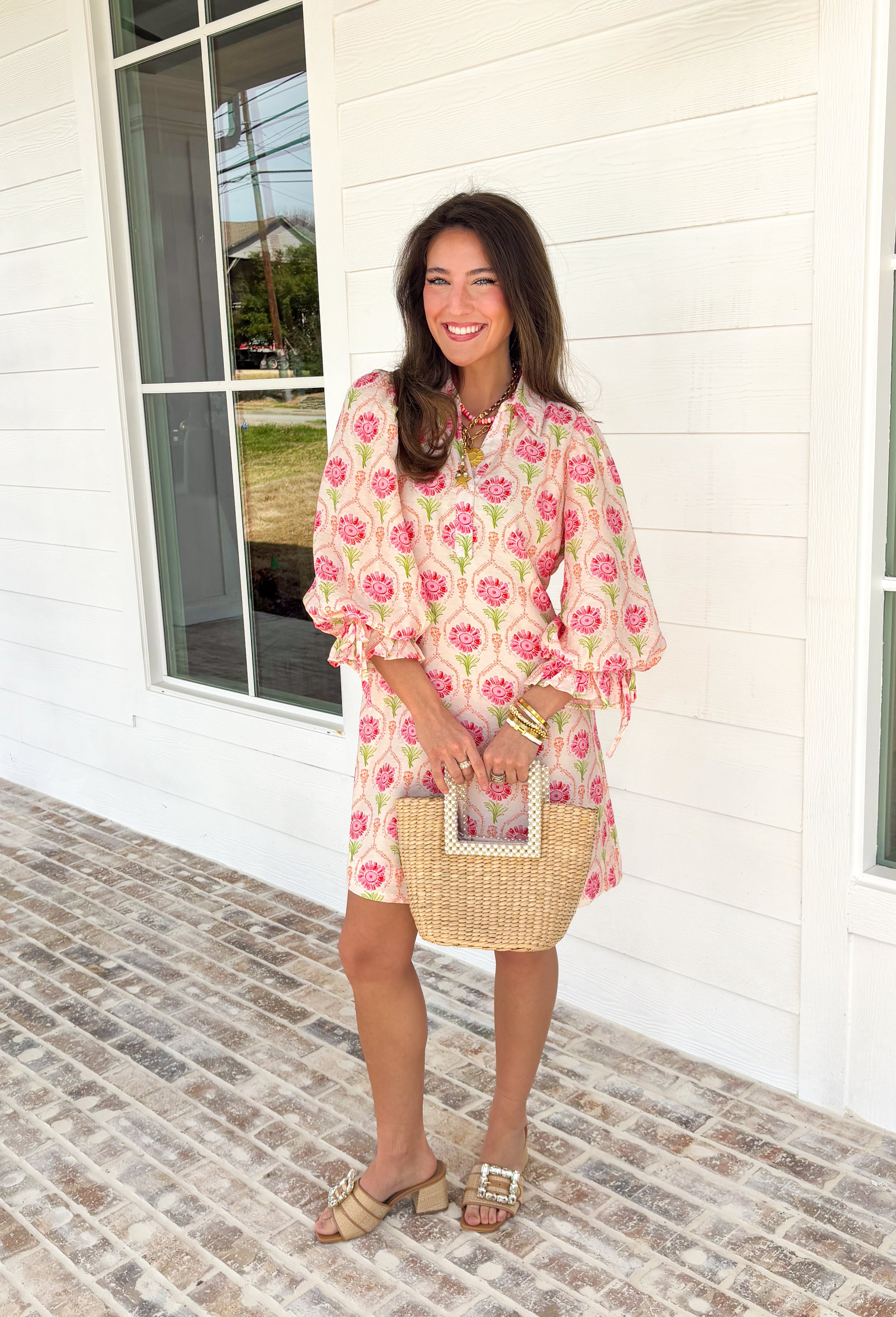 Bright, breezy, and full of spring charm, this off-white dress by Entro is an easy favorite for sunny days ahead. Featuring a colorful floral print with pops of pink, coral, and green, it feels cheerful and perfectly seasonal. The collared neckline adds a classic touch, while the ¾ length sleeves with elastic cuffs and adjustable tie details give it a relaxed, feminine finish. Fully lined for comfortable wear, this dress is effortlessly polished and ready for everything from brunch dates to spring events.
