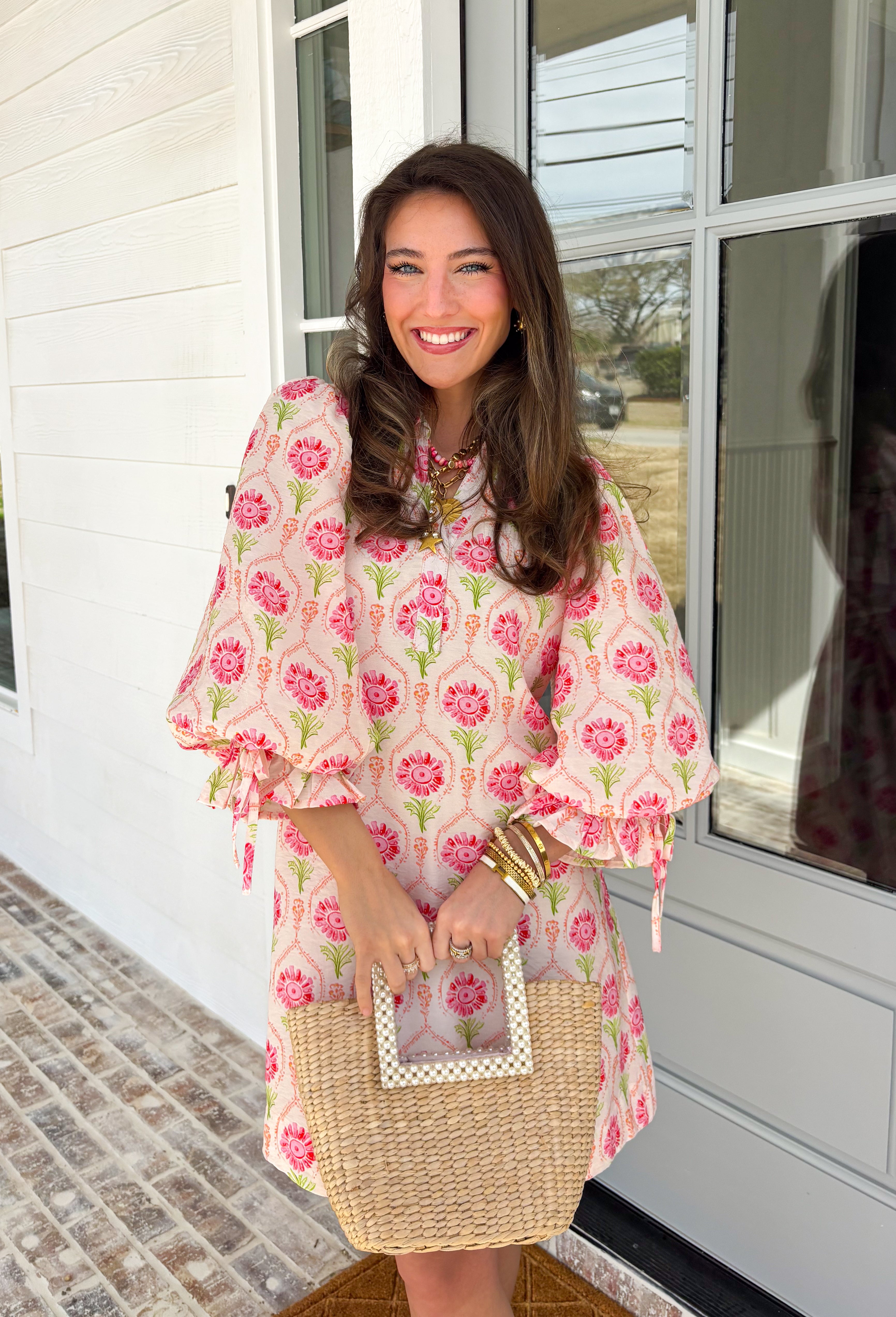 Bright, breezy, and full of spring charm, this off-white dress by Entro is an easy favorite for sunny days ahead. Featuring a colorful floral print with pops of pink, coral, and green, it feels cheerful and perfectly seasonal. The collared neckline adds a classic touch, while the ¾ length sleeves with elastic cuffs and adjustable tie details give it a relaxed, feminine finish. Fully lined for comfortable wear, this dress is effortlessly polished and ready for everything from brunch dates to spring events.