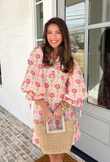 Bright, breezy, and full of spring charm, this off-white dress by Entro is an easy favorite for sunny days ahead. Featuring a colorful floral print with pops of pink, coral, and green, it feels cheerful and perfectly seasonal. The collared neckline adds a classic touch, while the ¾ length sleeves with elastic cuffs and adjustable tie details give it a relaxed, feminine finish. Fully lined for comfortable wear, this dress is effortlessly polished and ready for everything from brunch dates to spring events.