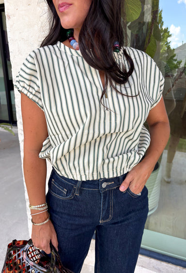 Bring a fresh pop of hunter green into your fall lineup with this striped top from Day + Moon. The cream and hunter green color combination feels classic for the season, while the front zipper detail gives it a sporty, modern touch. Elastic at the sleeves and hem creates an easy, comfortable shape that's perfect for busy days when you still want to feel put together. From football Saturdays and coffee runs to casual dinners and everyday errands, this top is an easy pick to wear with denim all season long.