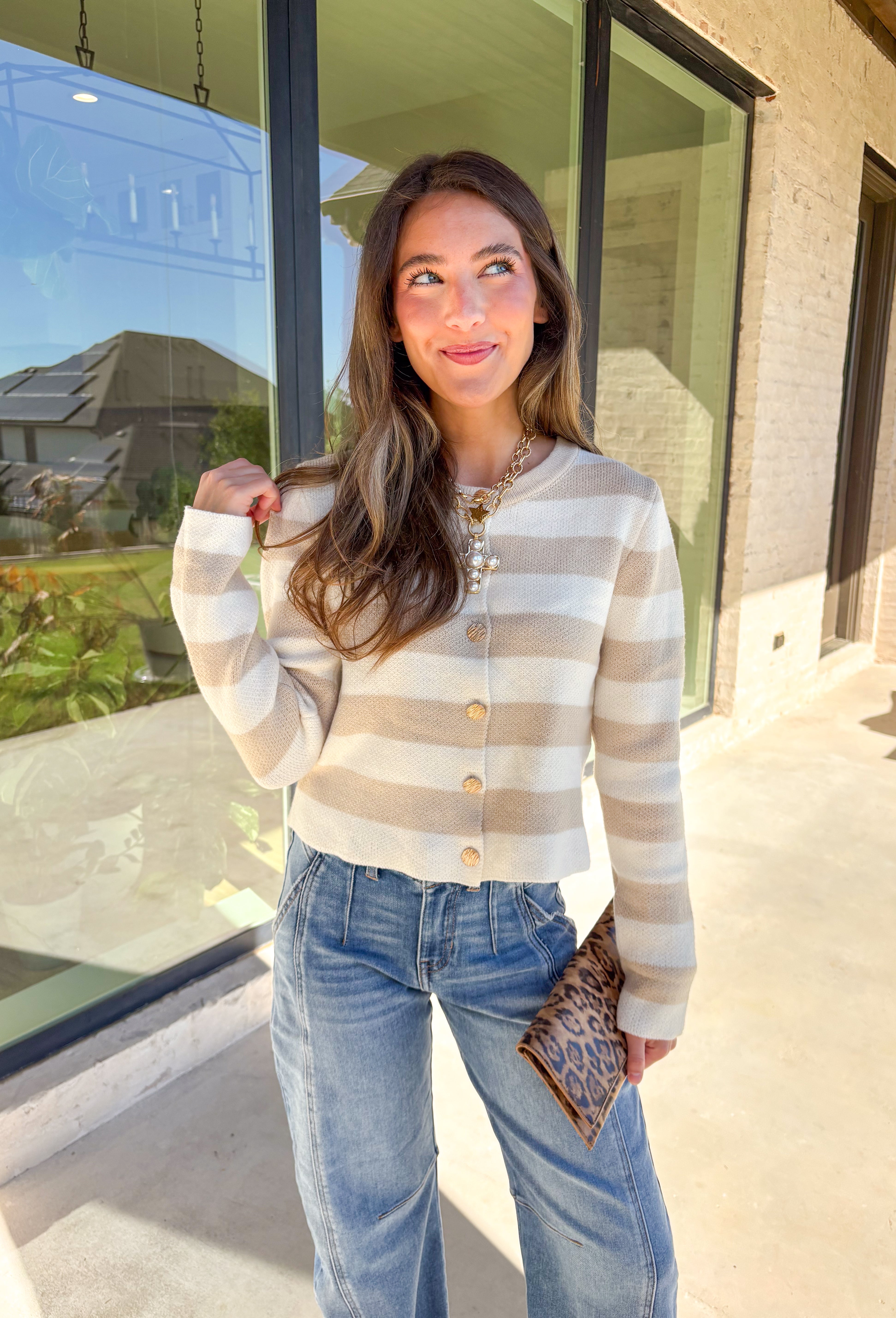 Wrap yourself in cozy-chic comfort with this neutral striped cardigan, designed with a flattering fit and glam gold textured buttons down the front. Whether you're heading into the office or sipping cider on the weekend, this layering piece brings the perfect blend of classic style and a touch of shine. A fall staple that feels as good as it looks!