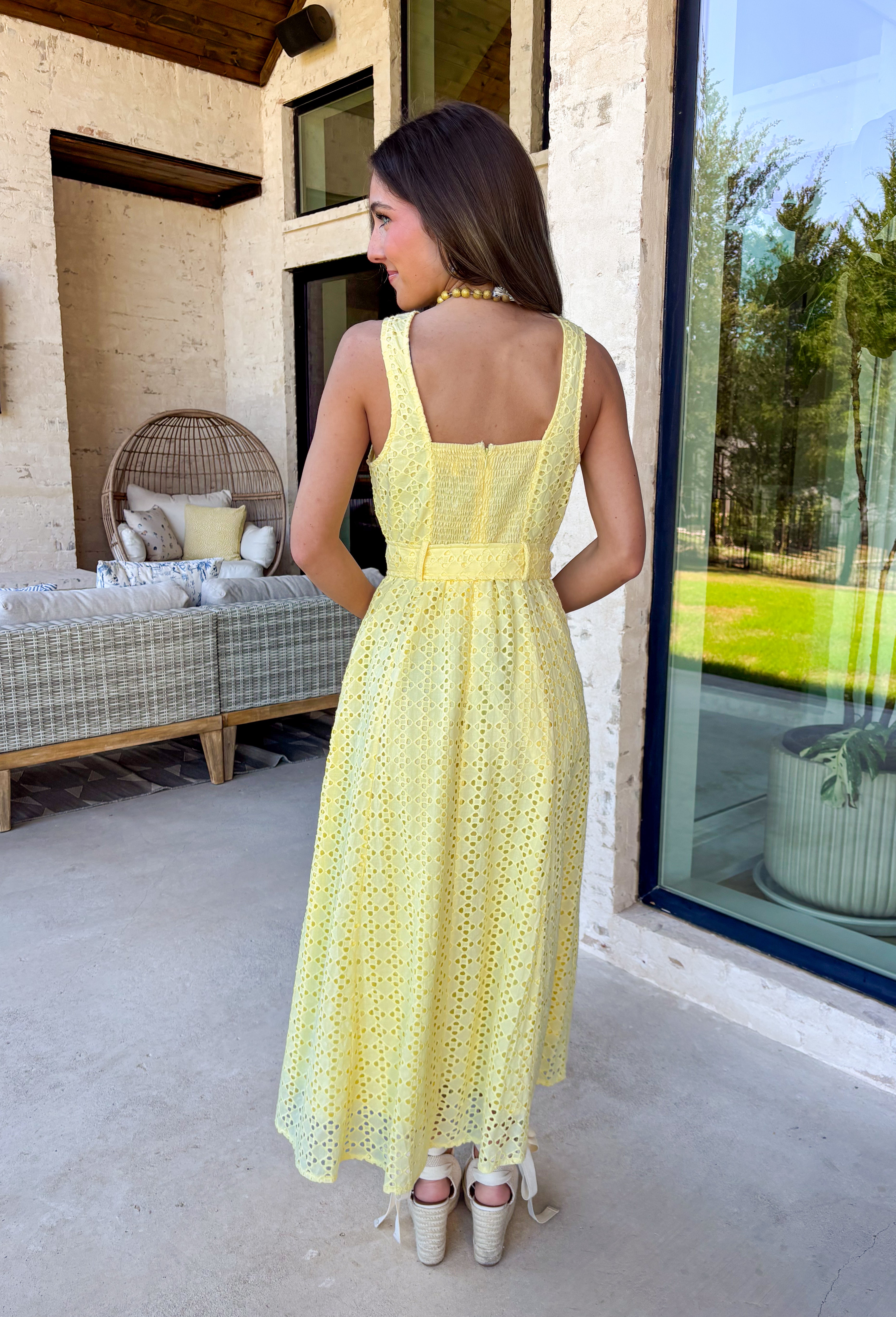 Bold, polished, and beautifully detailed — this lemon yellow eyelet lace midi dress is a true standout. The intricate eyelet lace gives it texture and dimension, while the gold textured button-down front adds a hint of shine that elevates the entire look. Designed with a matching belt featuring a gold buckle, this dress cinches the waist for a flattering, feminine silhouette. Smocking along the back provides comfortable stretch, and the back zipper closure keeps the fit secure and streamlined. 