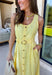 Bold, polished, and beautifully detailed — this lemon yellow eyelet lace midi dress is a true standout. The intricate eyelet lace gives it texture and dimension, while the gold textured button-down front adds a hint of shine that elevates the entire look. Designed with a matching belt featuring a gold buckle, this dress cinches the waist for a flattering, feminine silhouette. Smocking along the back provides comfortable stretch, and the back zipper closure keeps the fit secure and streamlined. 