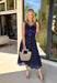 Bold, polished, and beautifully detailed — this navy eyelet lace midi dress is a true standout. The intricate eyelet lace gives it texture and dimension, while the gold textured button-down front adds a hint of shine that elevates the entire look. Designed with a matching belt featuring a gold buckle, this dress cinches the waist for a flattering, feminine silhouette. Smocking along the back provides comfortable stretch, and the back zipper closure keeps the fit secure and streamlined.