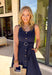 Bold, polished, and beautifully detailed — this navy eyelet lace midi dress is a true standout. The intricate eyelet lace gives it texture and dimension, while the gold textured button-down front adds a hint of shine that elevates the entire look. Designed with a matching belt featuring a gold buckle, this dress cinches the waist for a flattering, feminine silhouette. Smocking along the back provides comfortable stretch, and the back zipper closure keeps the fit secure and streamlined.