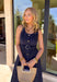 Bold, polished, and beautifully detailed — this navy eyelet lace midi dress is a true standout. The intricate eyelet lace gives it texture and dimension, while the gold textured button-down front adds a hint of shine that elevates the entire look. Designed with a matching belt featuring a gold buckle, this dress cinches the waist for a flattering, feminine silhouette. Smocking along the back provides comfortable stretch, and the back zipper closure keeps the fit secure and streamlined.